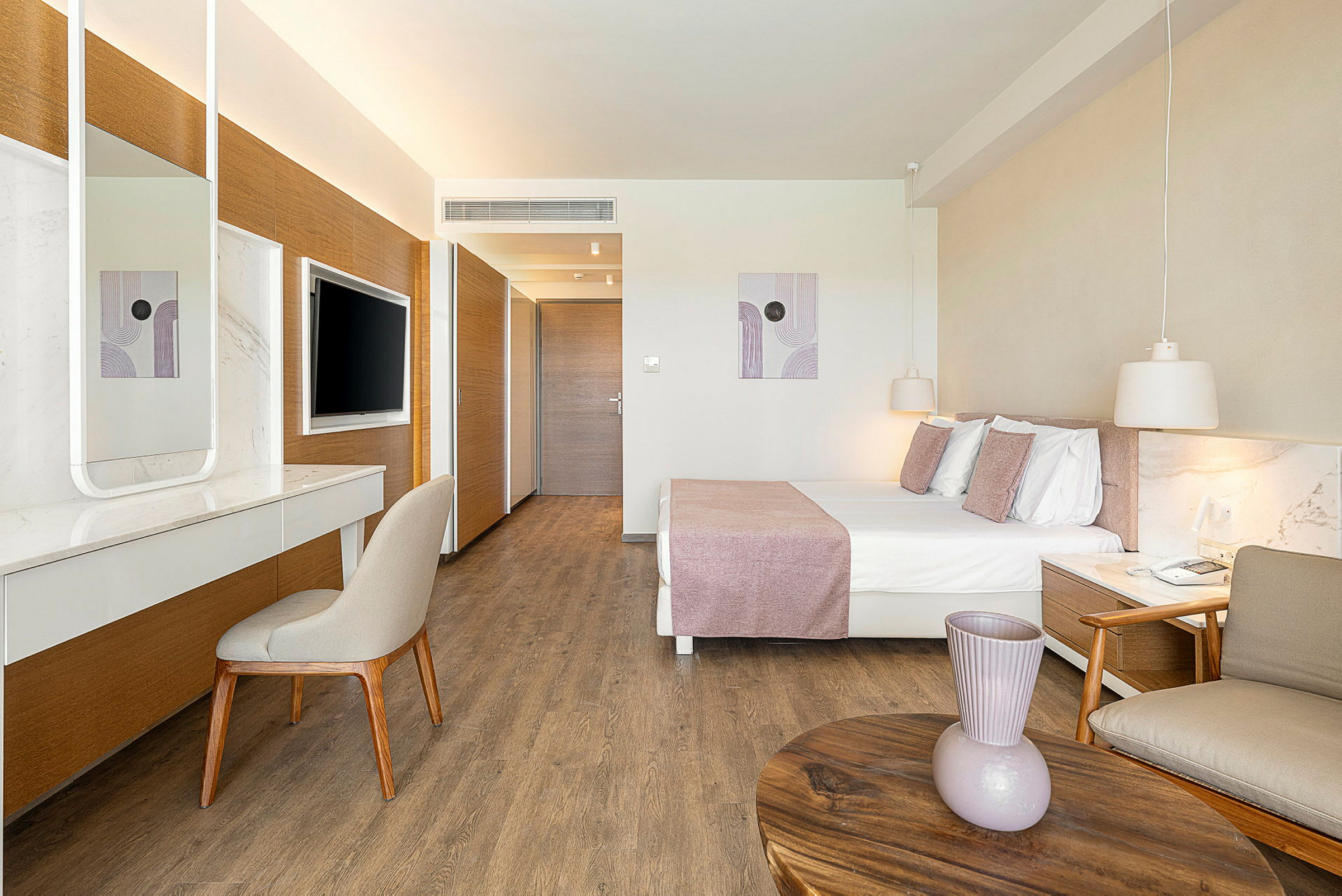 Bild av ett moderne hotellrum med en dubbelsäng, ett skrivbord och en väggmonterad TV. (AI-genererad text)