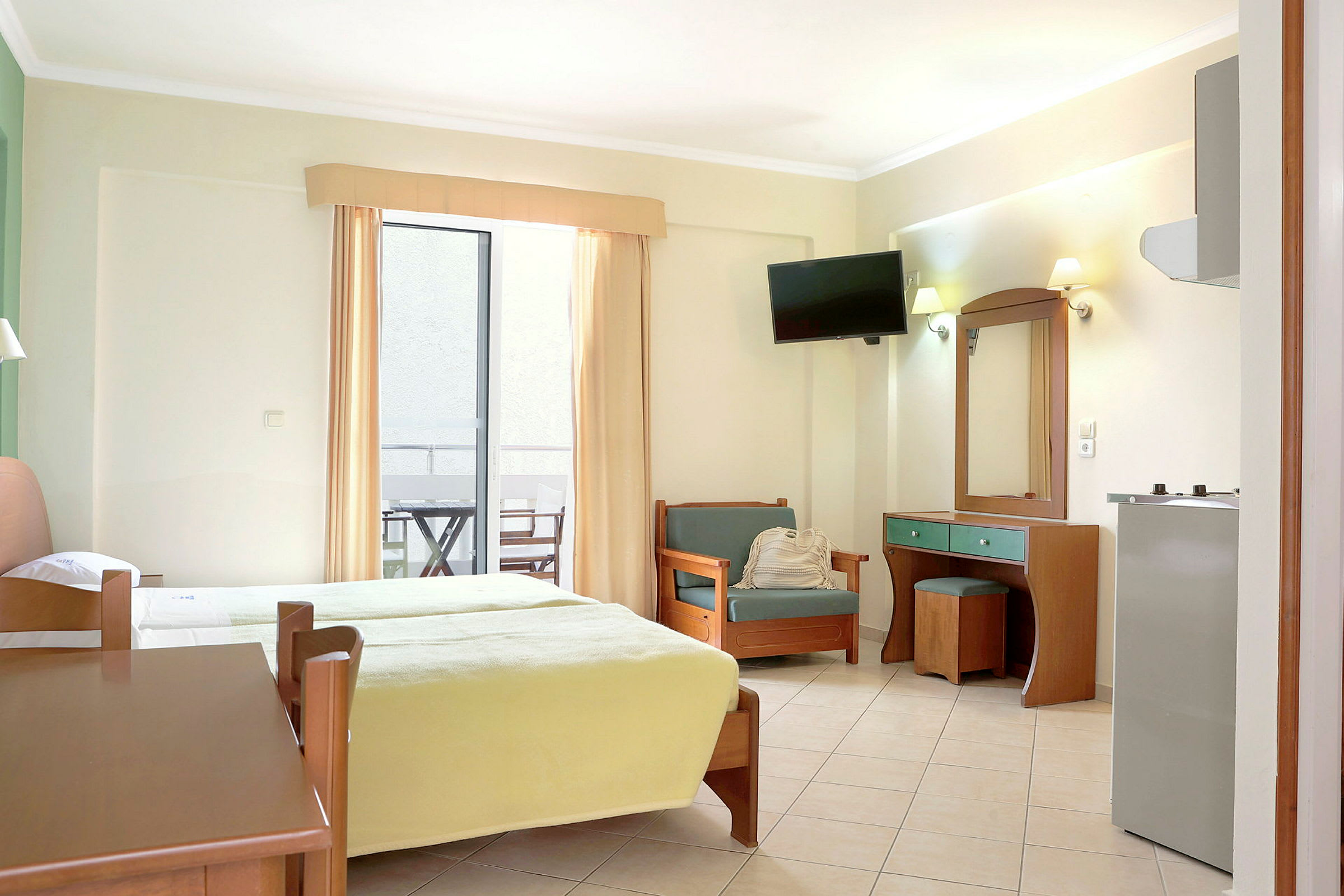 Ett hotellrum med två sängar, en sittplats och ett skrivbord. Det finns också en balkong med möbler. (AI-genererad text)