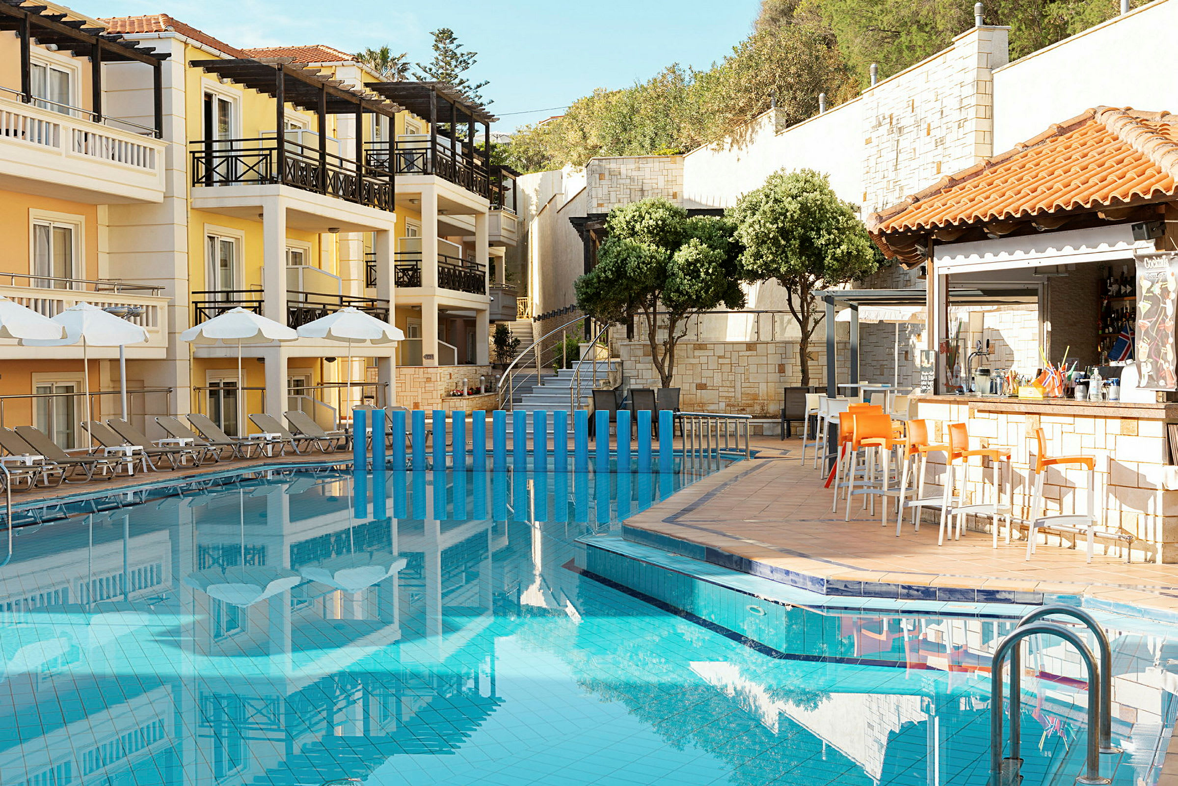 Bild av en hotellpool med solstolar och parasoller på sidan samt en bar med stolar. (AI-genererad text)