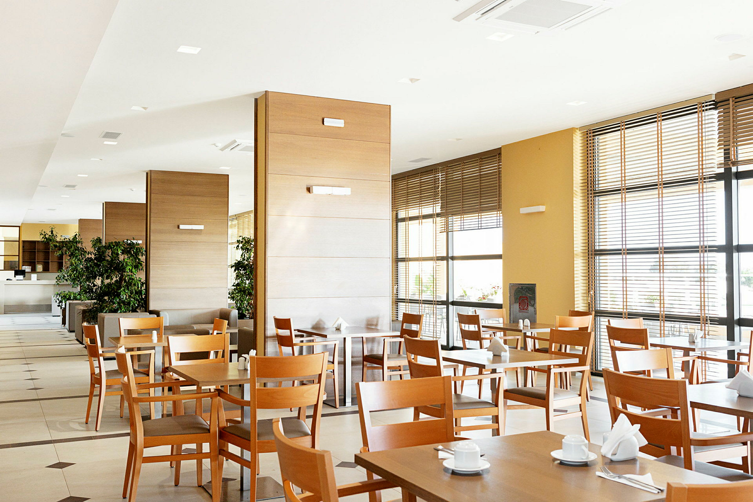 Interiör av en restaurang med träbord och stolar. (AI-genererad text)