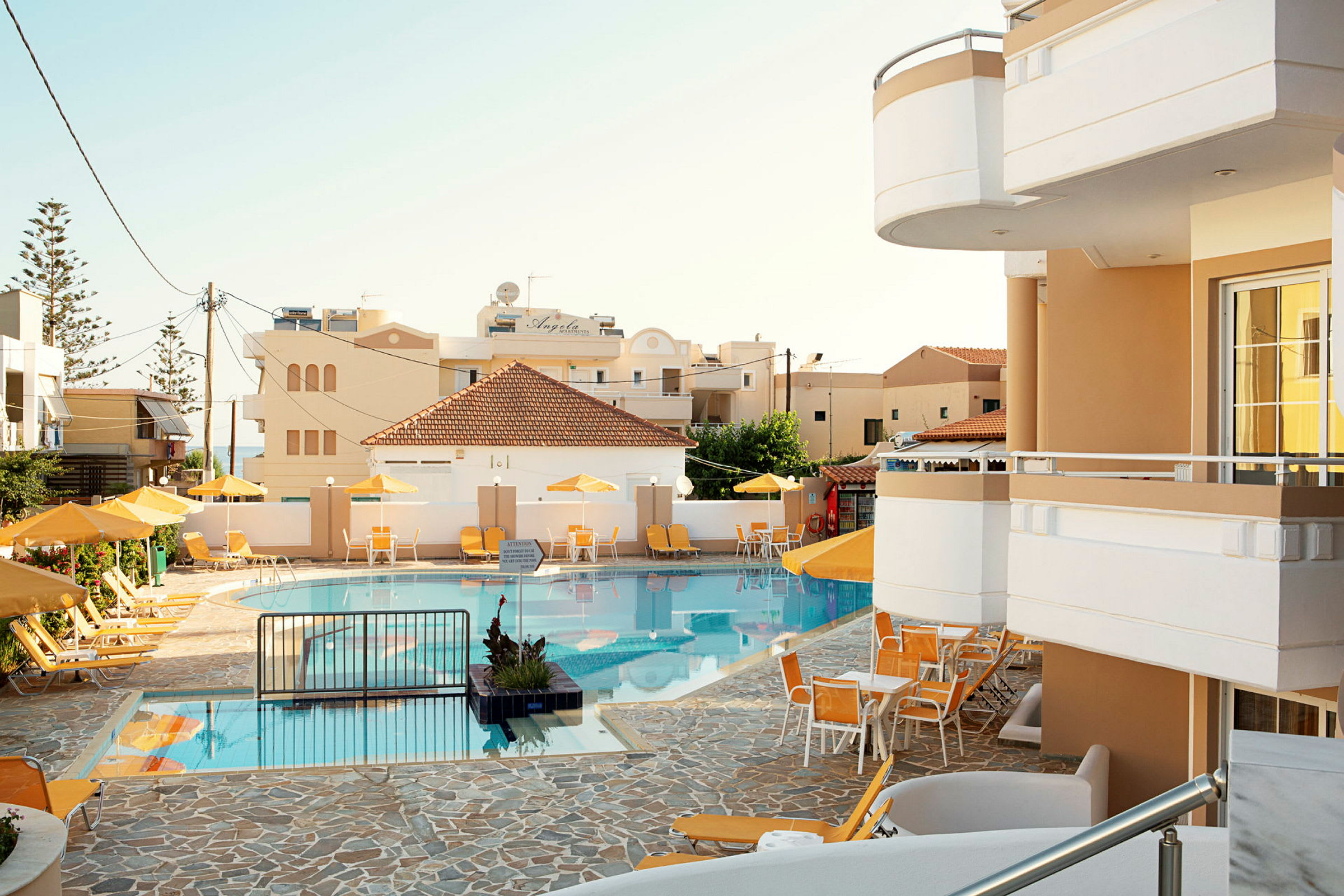 En pool med solstolar och parasoller vid ett hotell. (AI-genererad text)