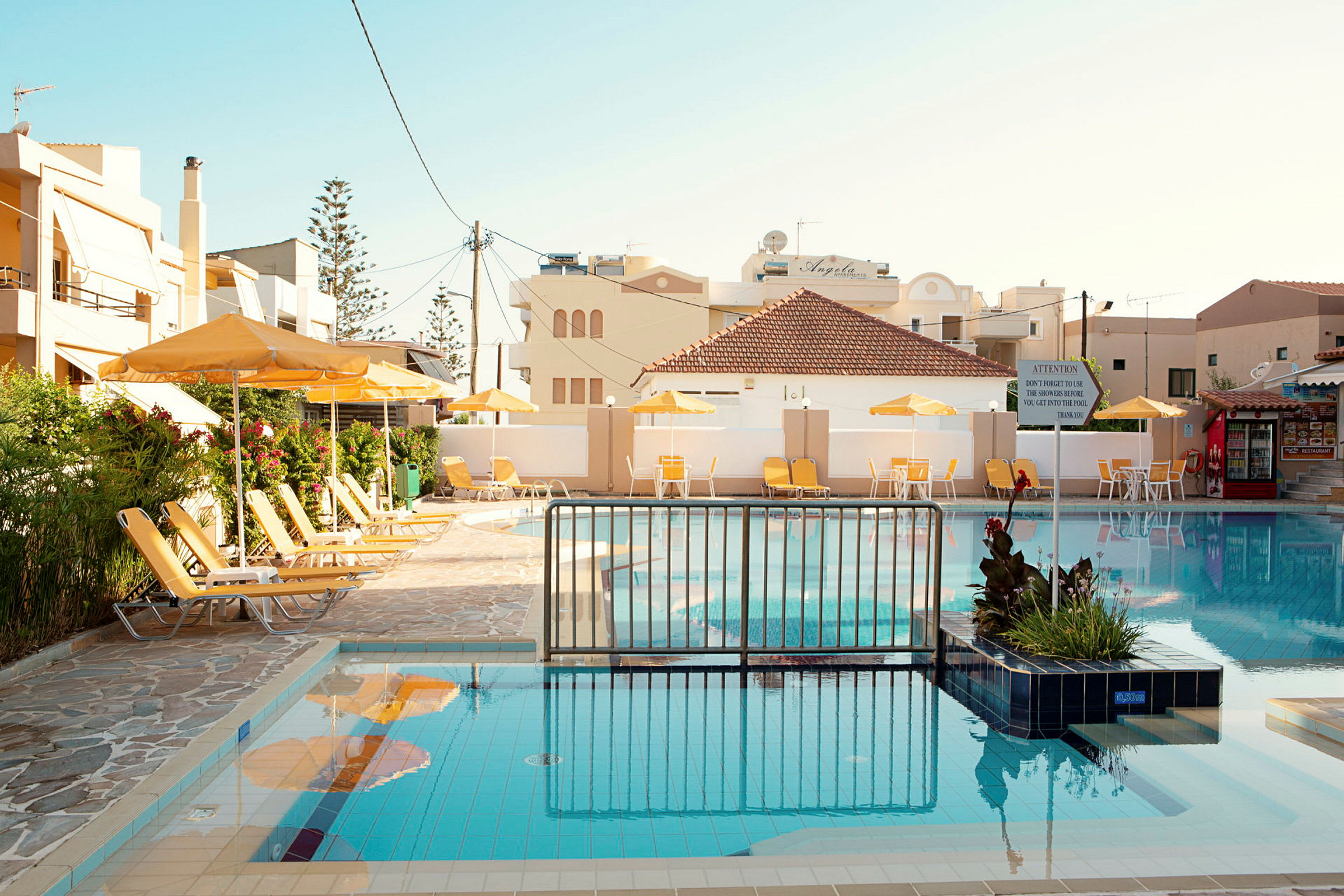 Bild av en hotellpool omgivet av solstolar och parasoller. (AI-genererad text)