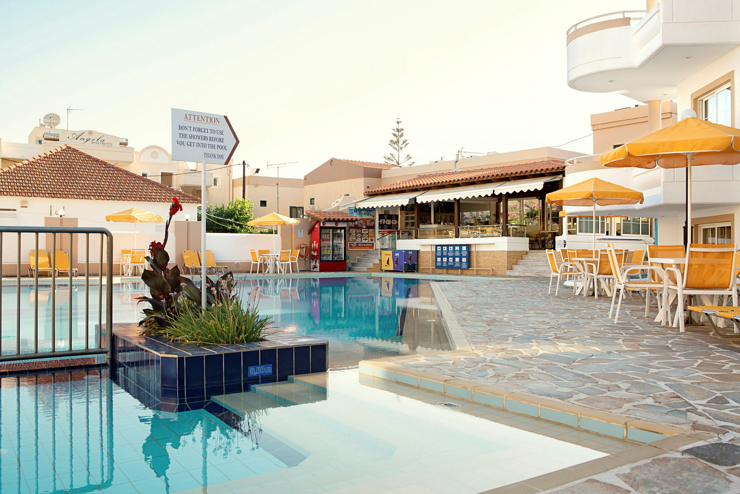 Utomhuspool vid hotell med solstolar och parasoller. (AI-genererad text)