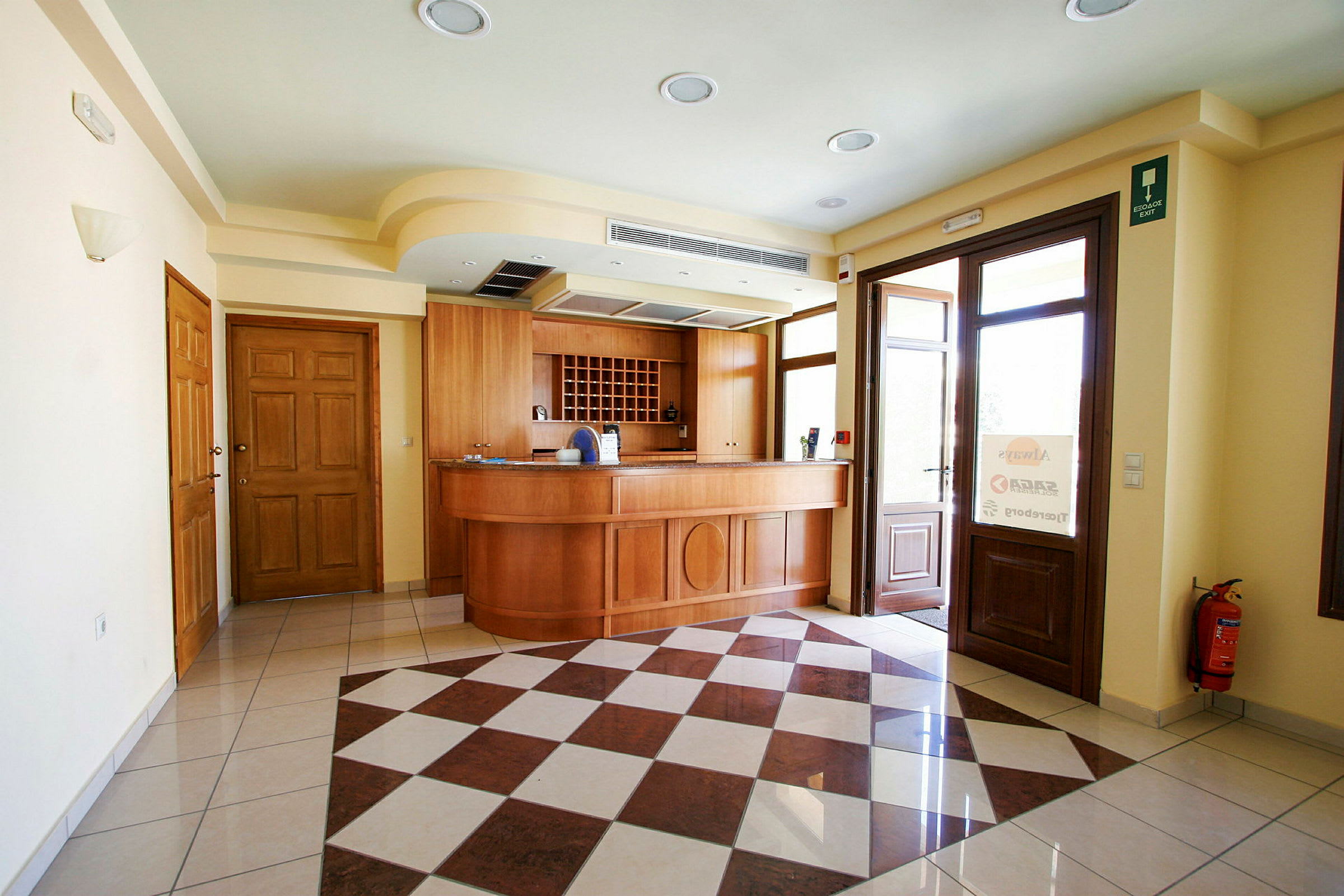 Reception med trägolv och möbler samt stora glasdörrar. (AI-genererad text)
