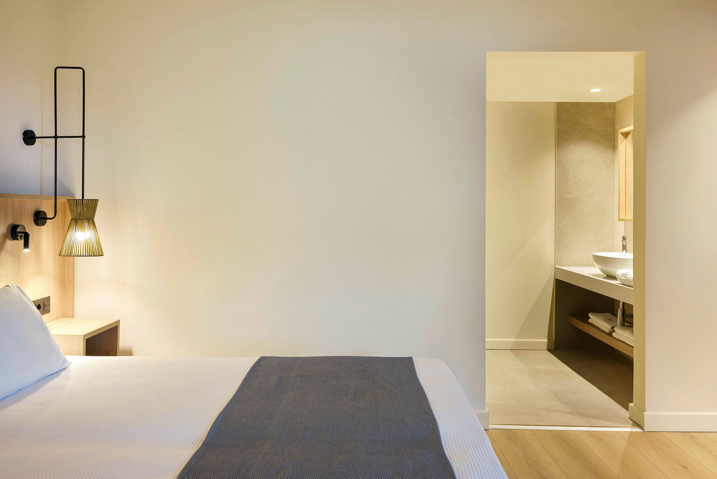 Hotellrum med säng och en öppning till badrum. (AI-genererad text)