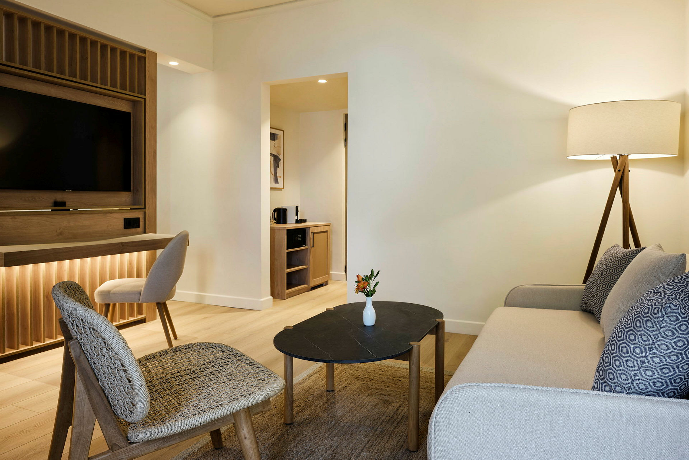 Ett hotellrum med en sittgrupp, inklusive en soffa, stolar och ett soffbord. (AI-genererad text)