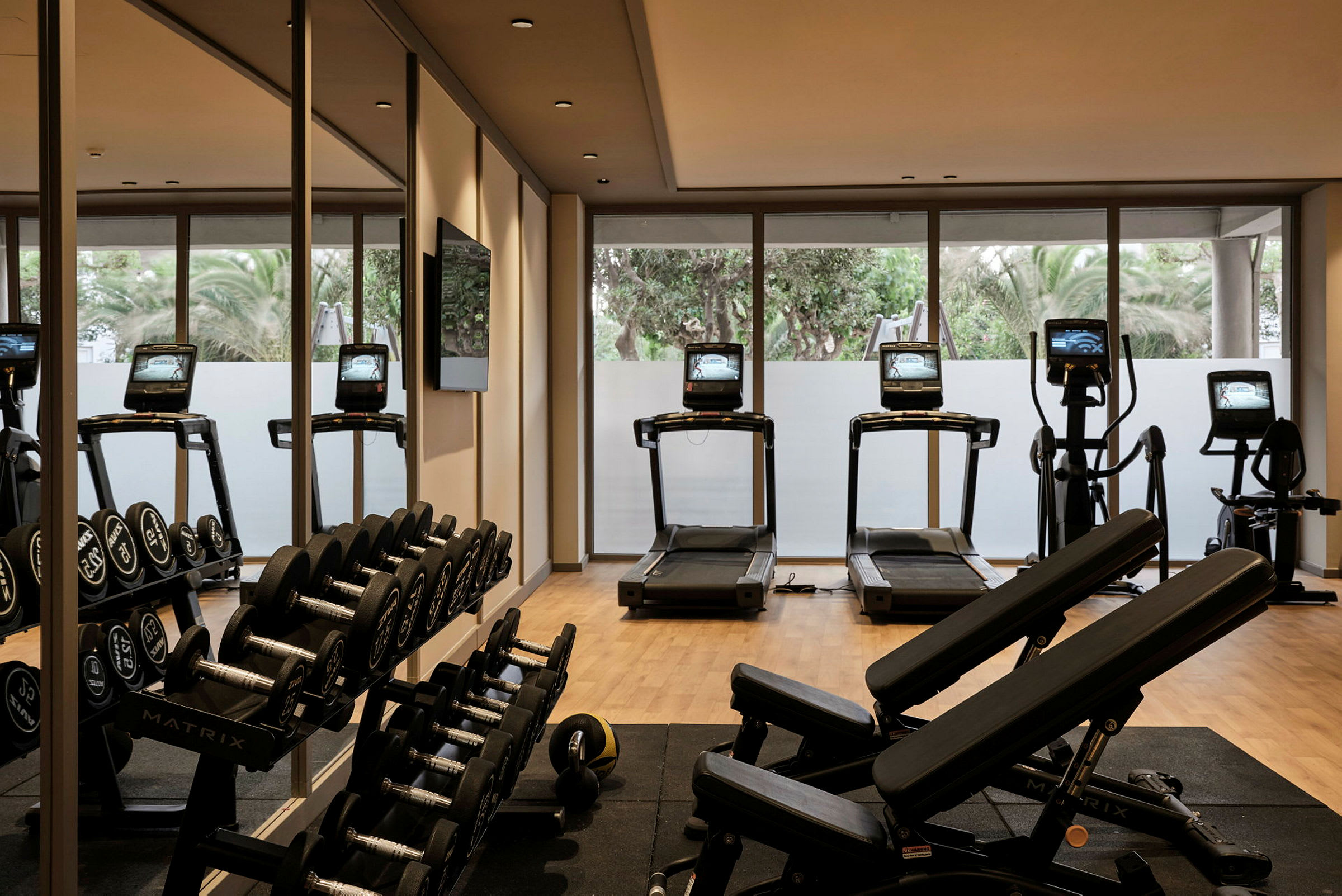 Ett gym med träningsutrustning inklusive löpband och hantlar. (AI-genererad text)