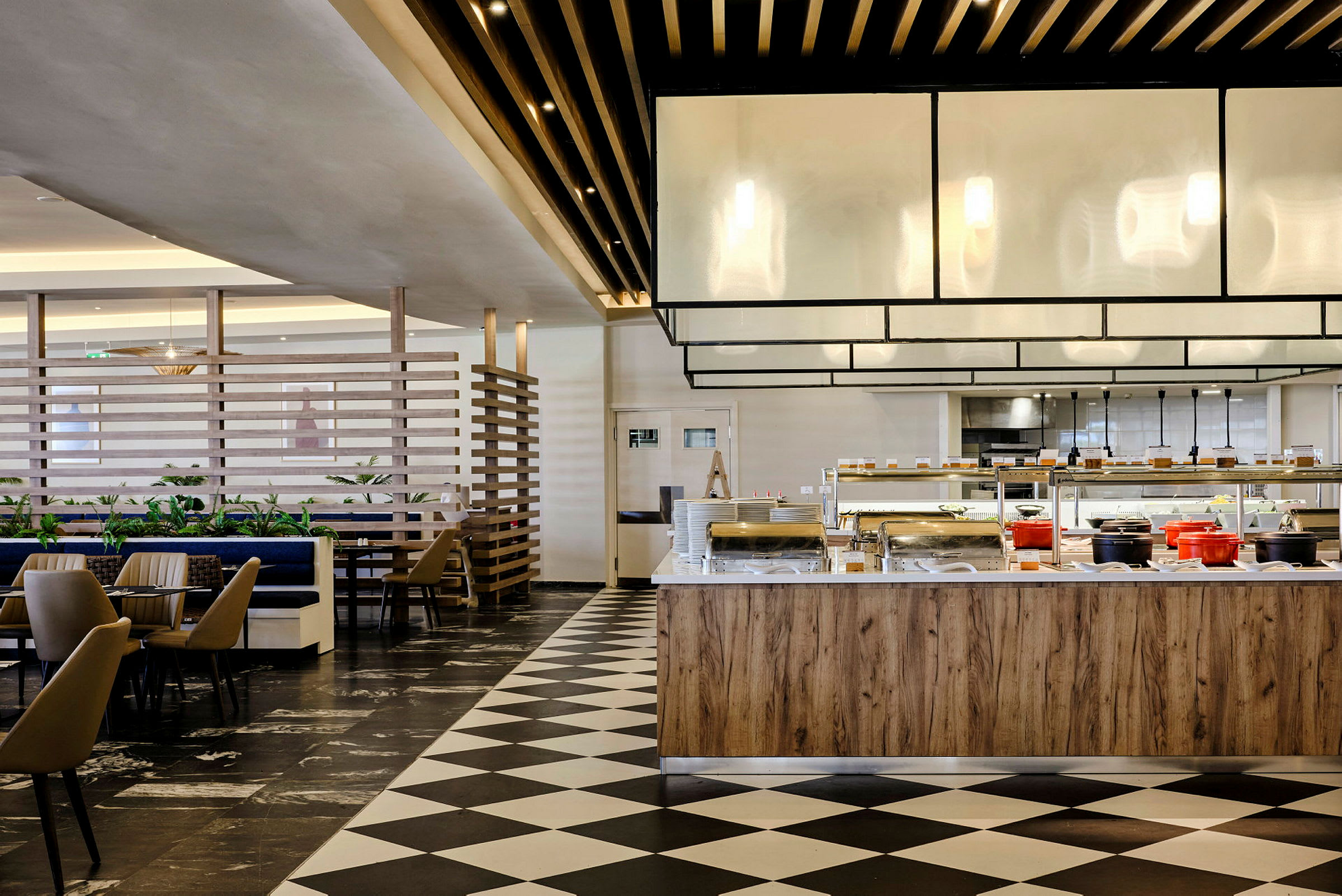 Interiör av en restaurang med bufféområde och sittplatser. (AI-genererad text)