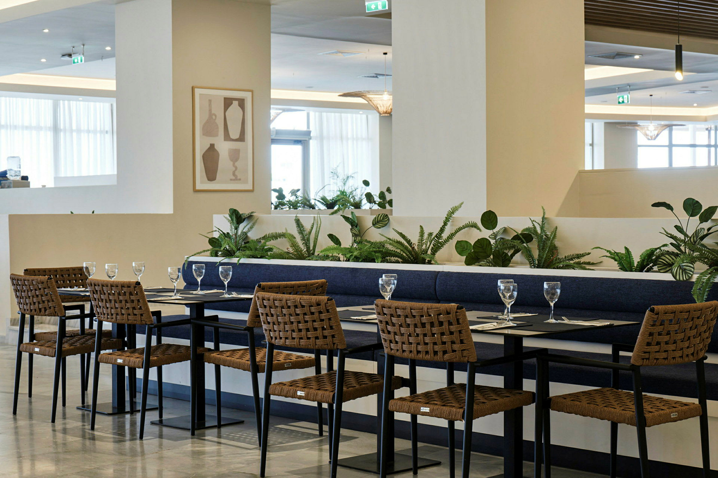 Matplats med bord och stolar i modern stil, omgiven av grönska. (AI-genererad text)