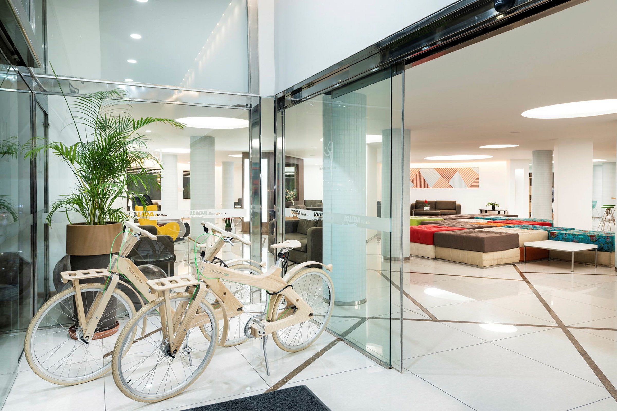 En hotellobby med soffor, bord och dekorationer, samt träcyklar vid ingången. (AI-genererad text)