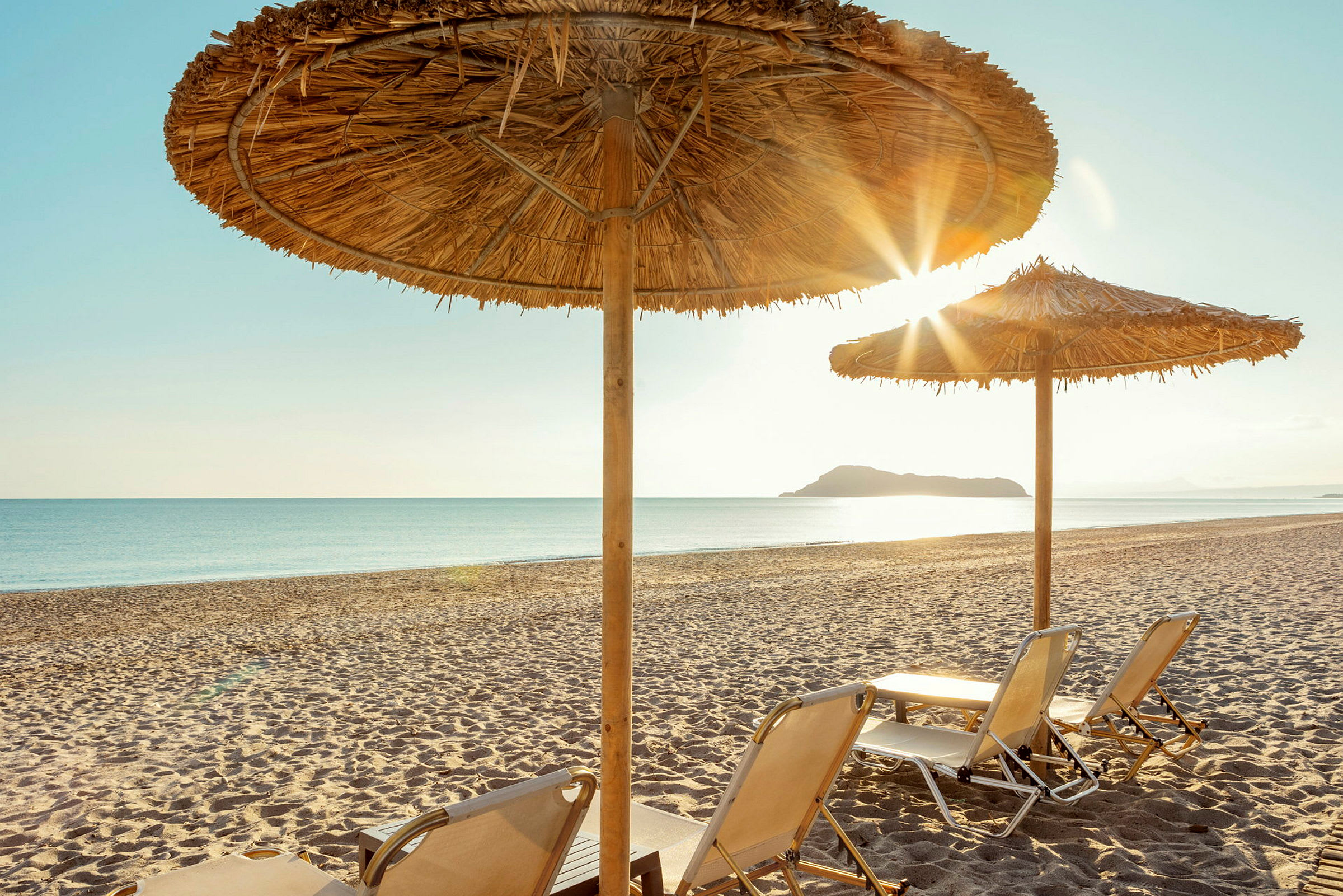 Solstolar på en sandstrand under parasoller. (AI-genererad text)