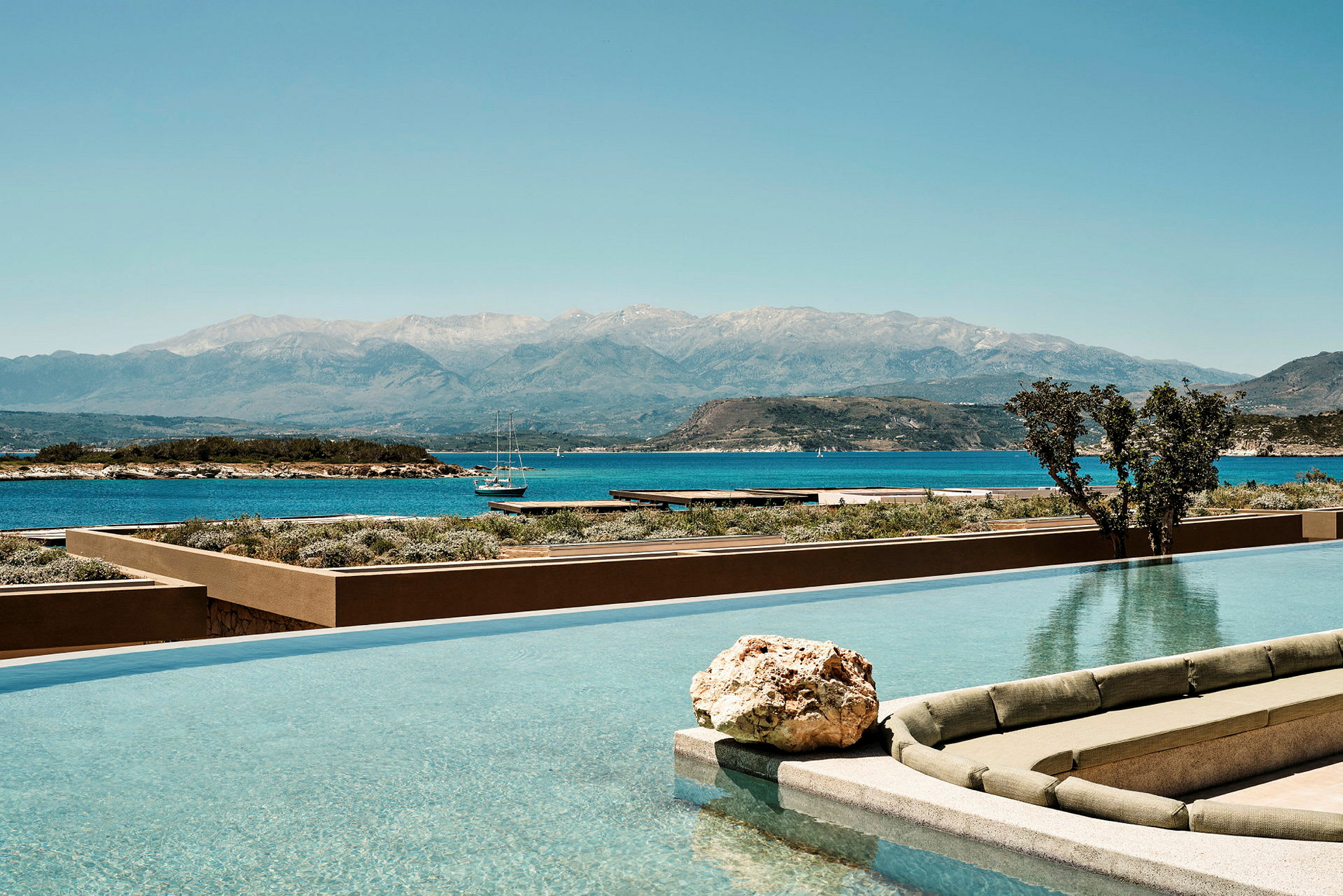 En infinitypool med utsikt över havet och en bergskedja i bakgrunden. (AI-genererad text)
