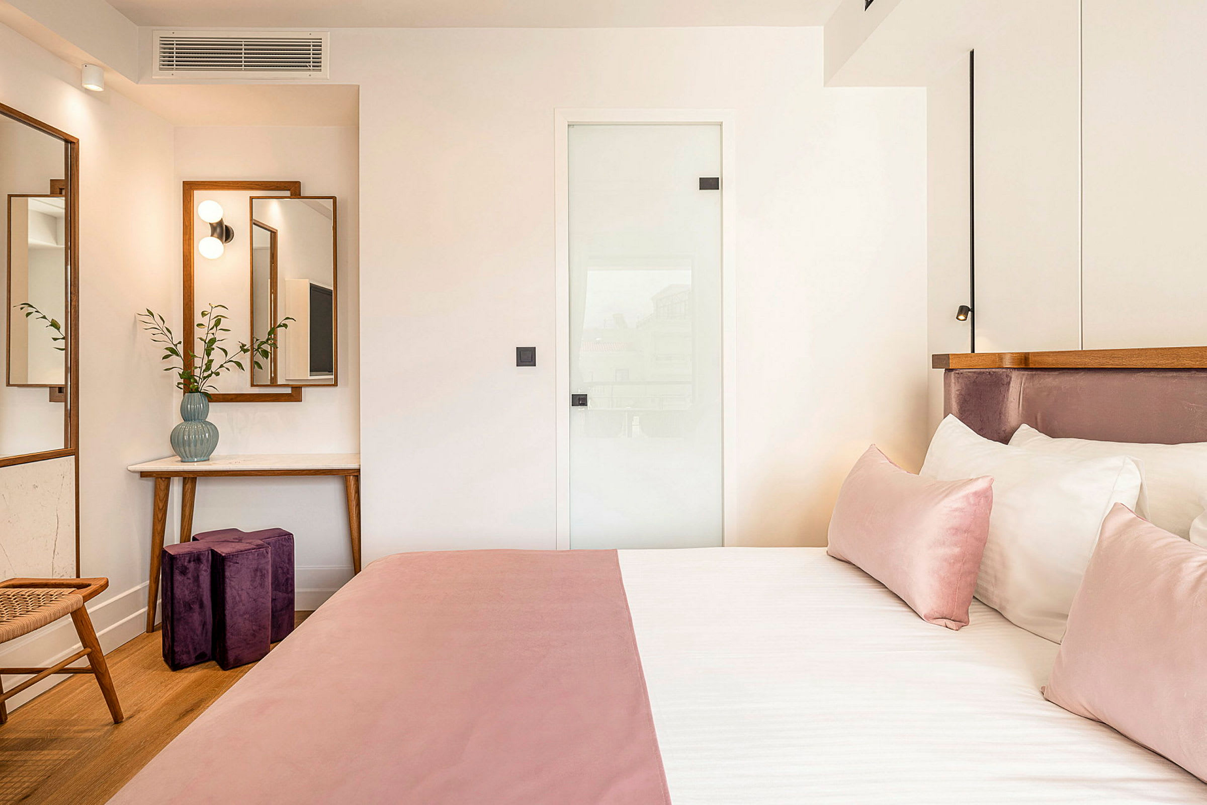 Ett hotellrum med rosa sängkläder och trendig inredning. (AI-genererad text)