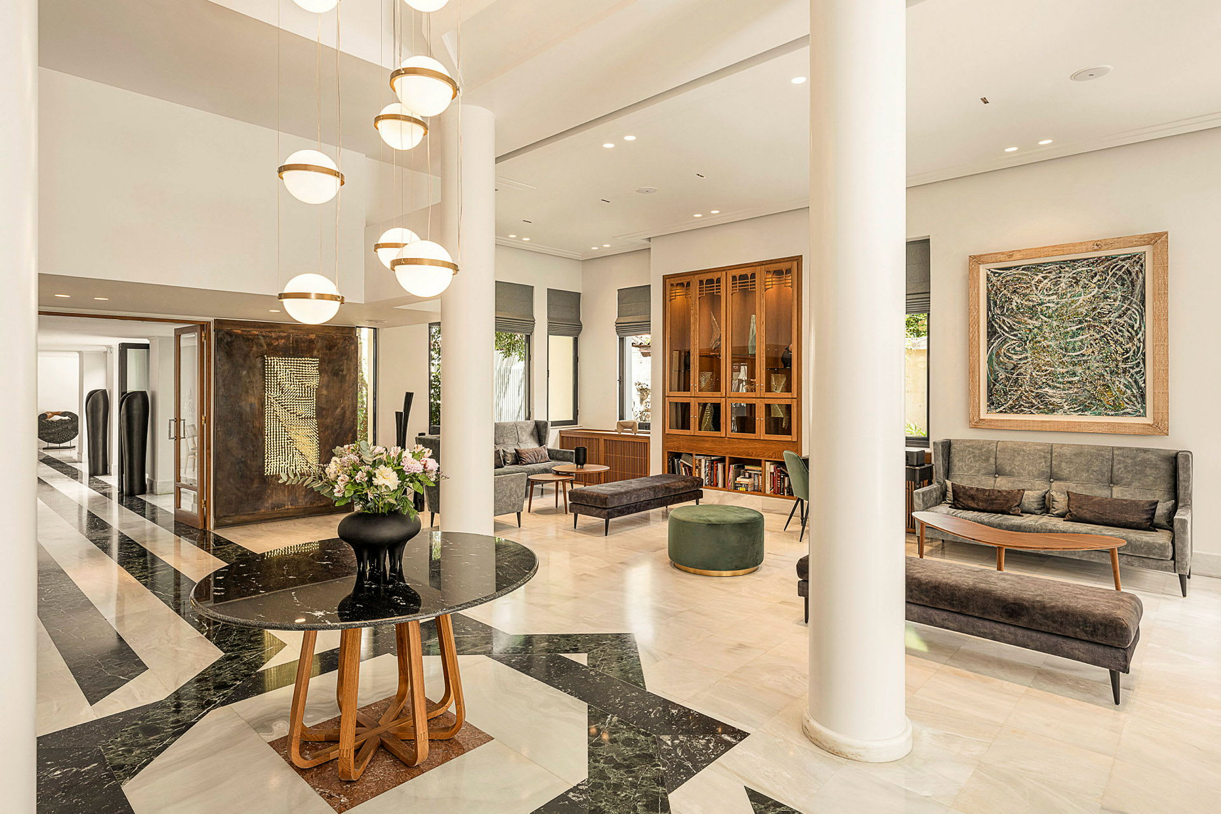 Modernt designad hotellobby med marmorgolv, ljusa möbler och hängande lampor. (AI-genererad text)