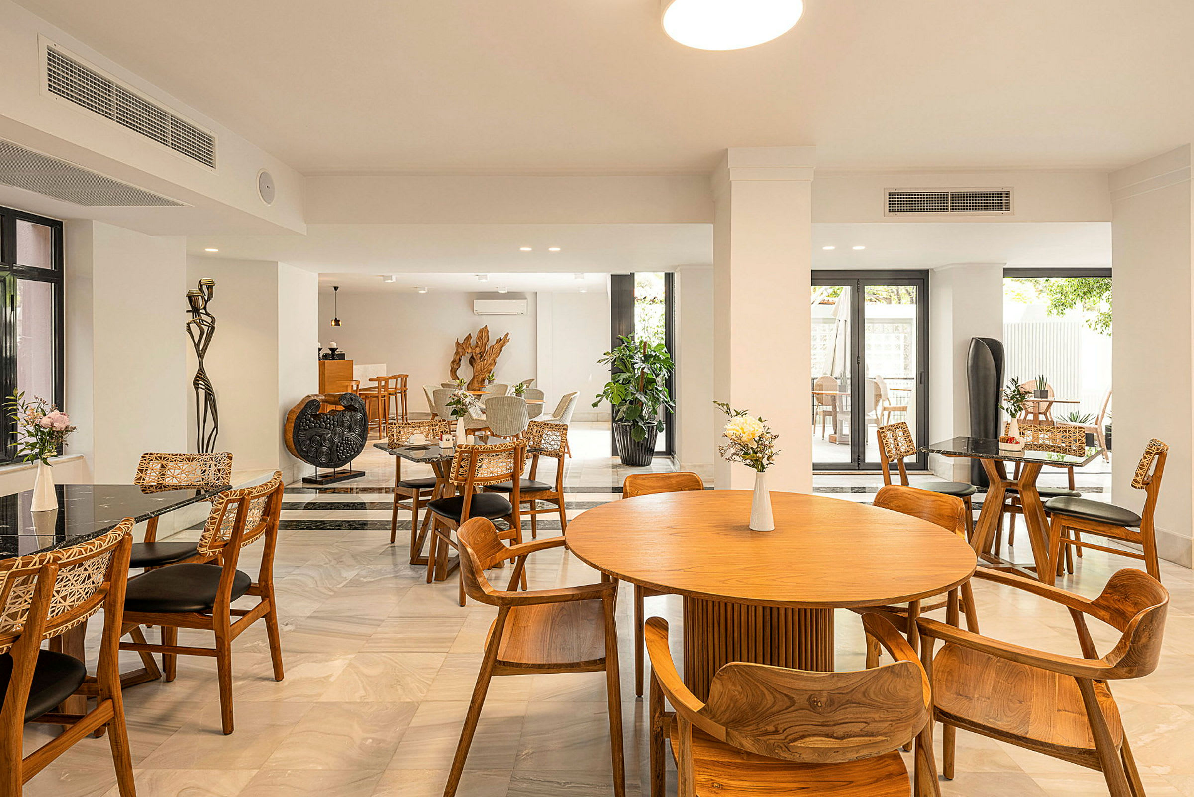 En inomhusrestaurang med bord och stolar av trä och modern inredning. (AI-genererad text)