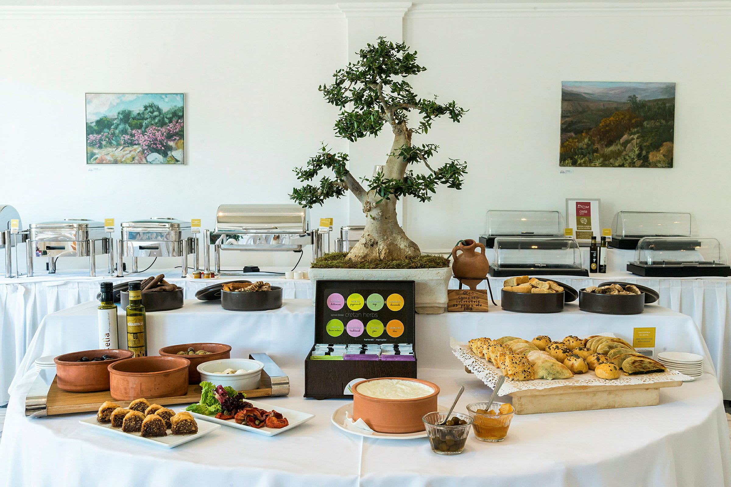 Bufférum med ett dukat bord fyllt med olika maträtter och en dekorativ krukväxt på bordet. (AI-genererad text)