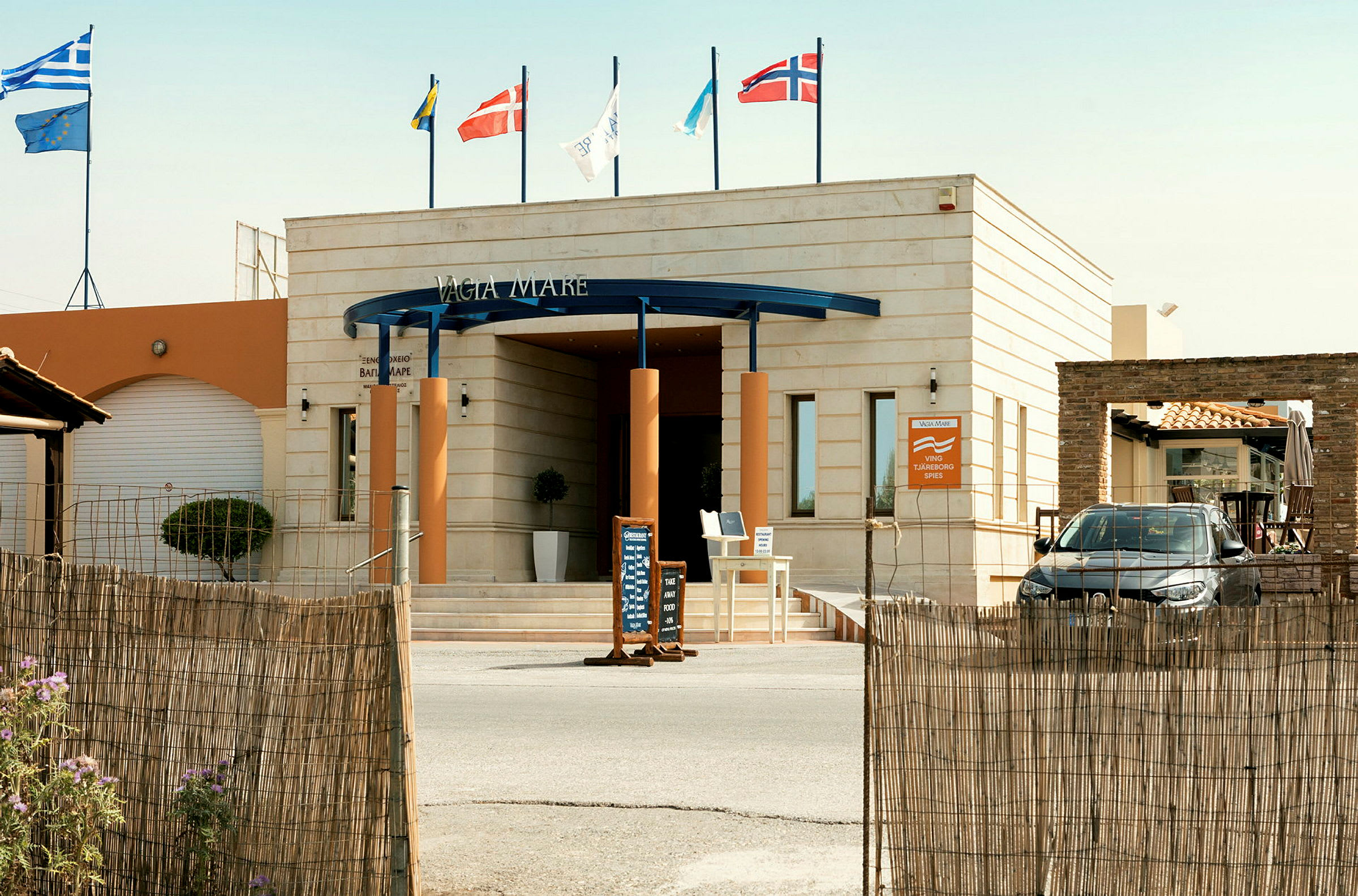 Entré till ett hotell med flaggor ovanför. (AI-genererad text)