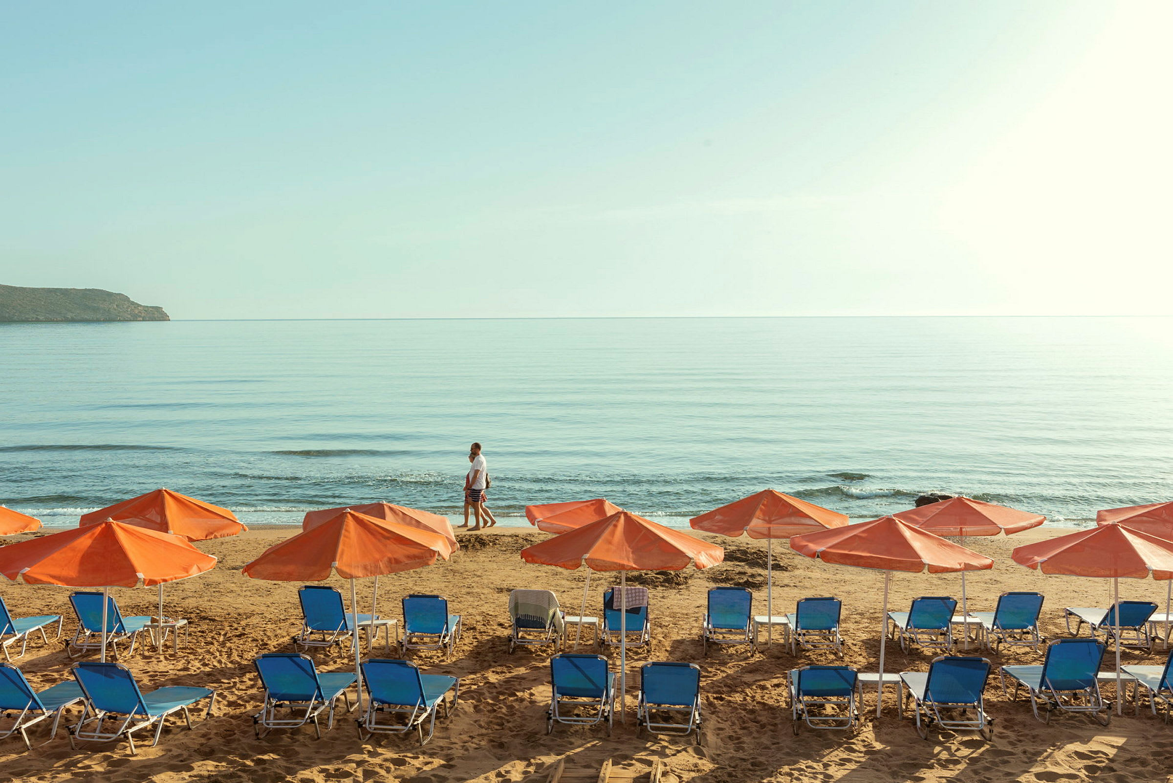 Solstolar och parasoller på en strand vid havet. (AI-genererad text)