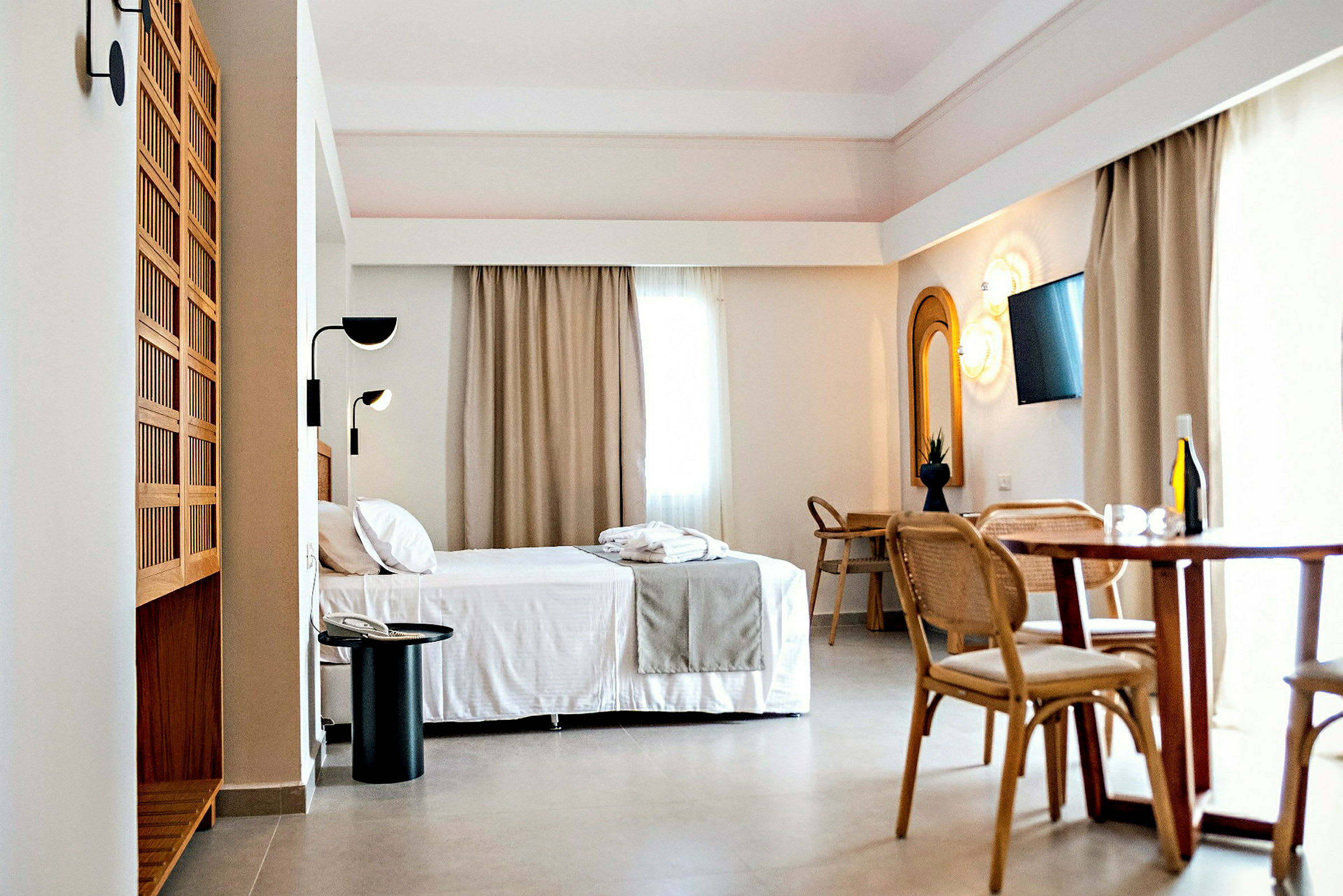Hotellrum med säng, matbord och skrivbord. (AI-genererad text)