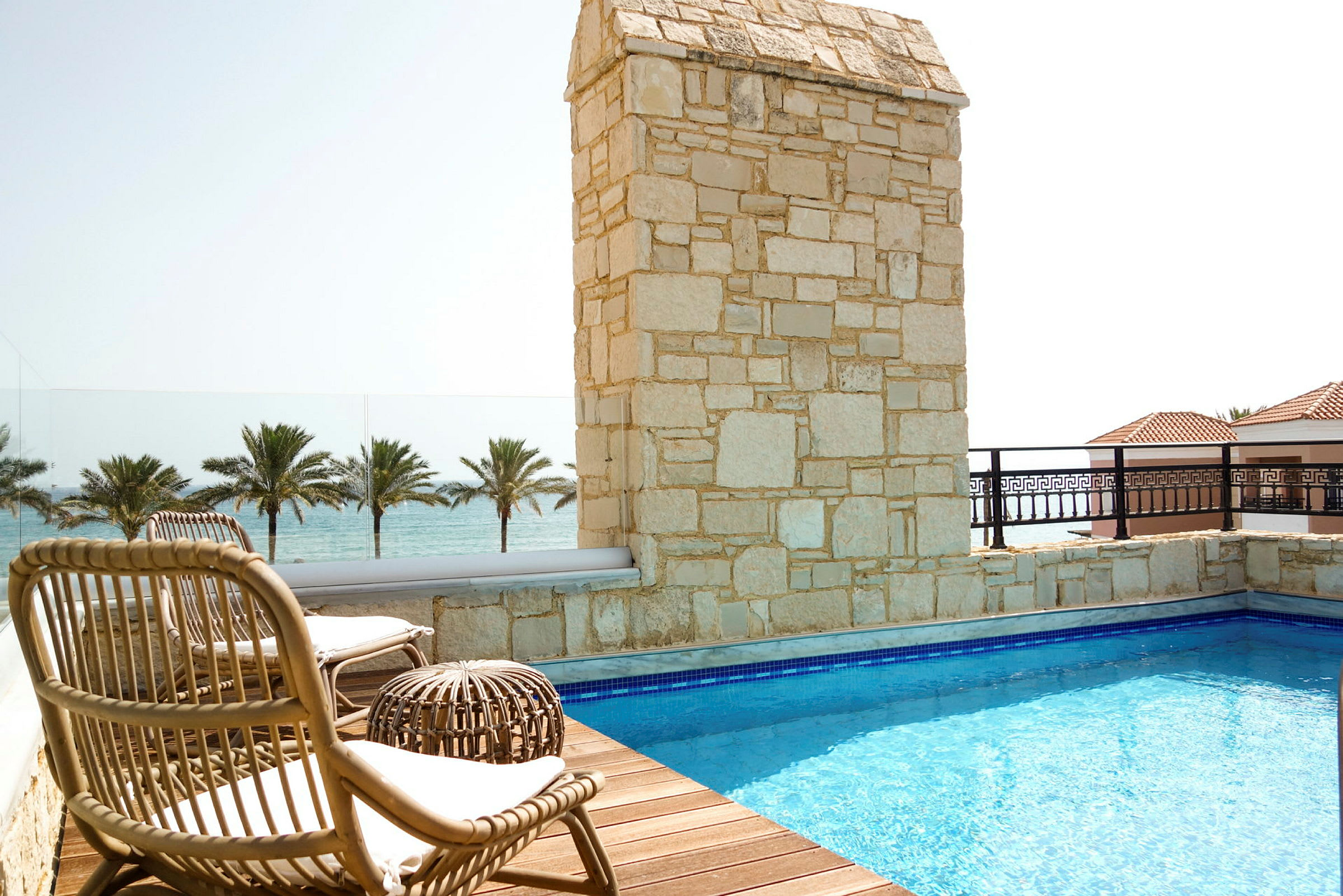Terrass med pool, solstolar och utsikt över havet. (AI-genererad text)