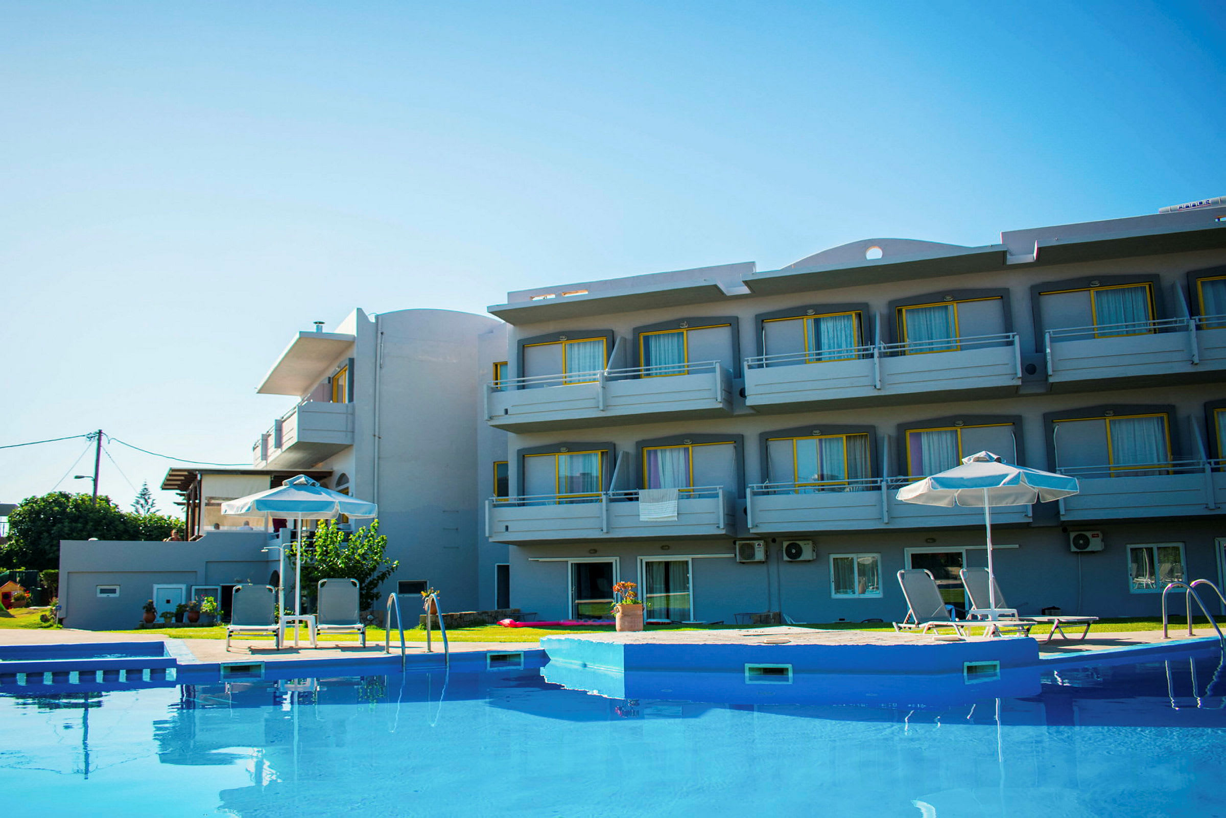 Ett hotell med balkonger och en pool i förgrunden. (AI-genererad text)