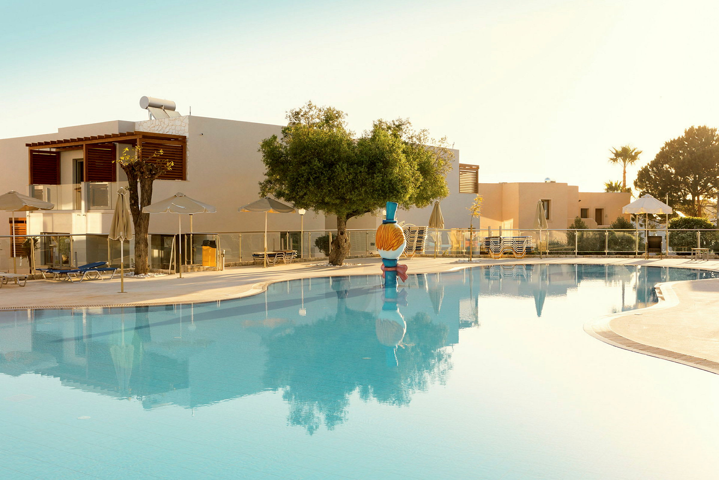 Swimmingpool vid hotell med solstolar och parasoller runt om. (AI-genererad text)