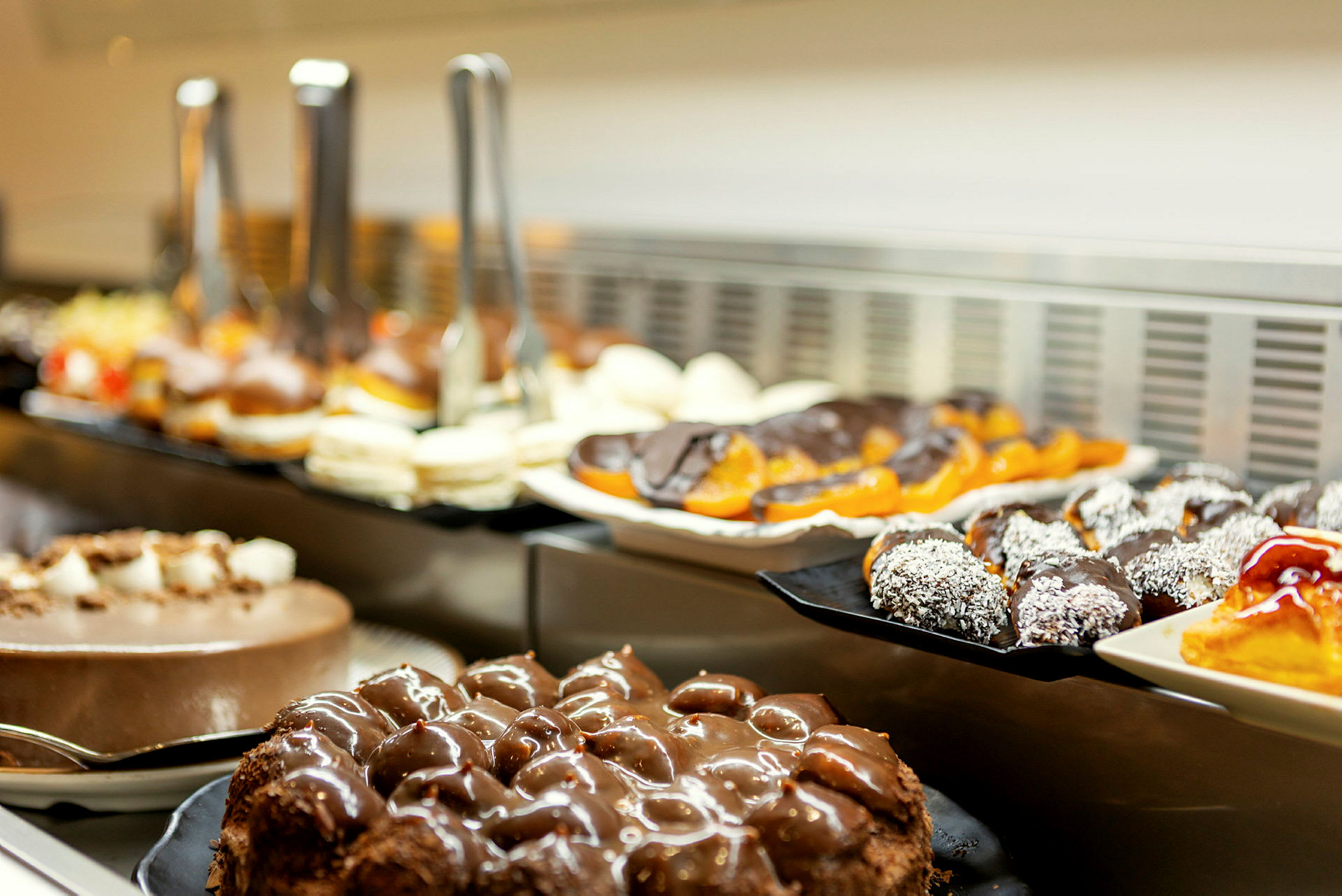 Ett bord med olika bakverk, inklusive chokladtårtor och andra sötsaker. (AI-genererad text)