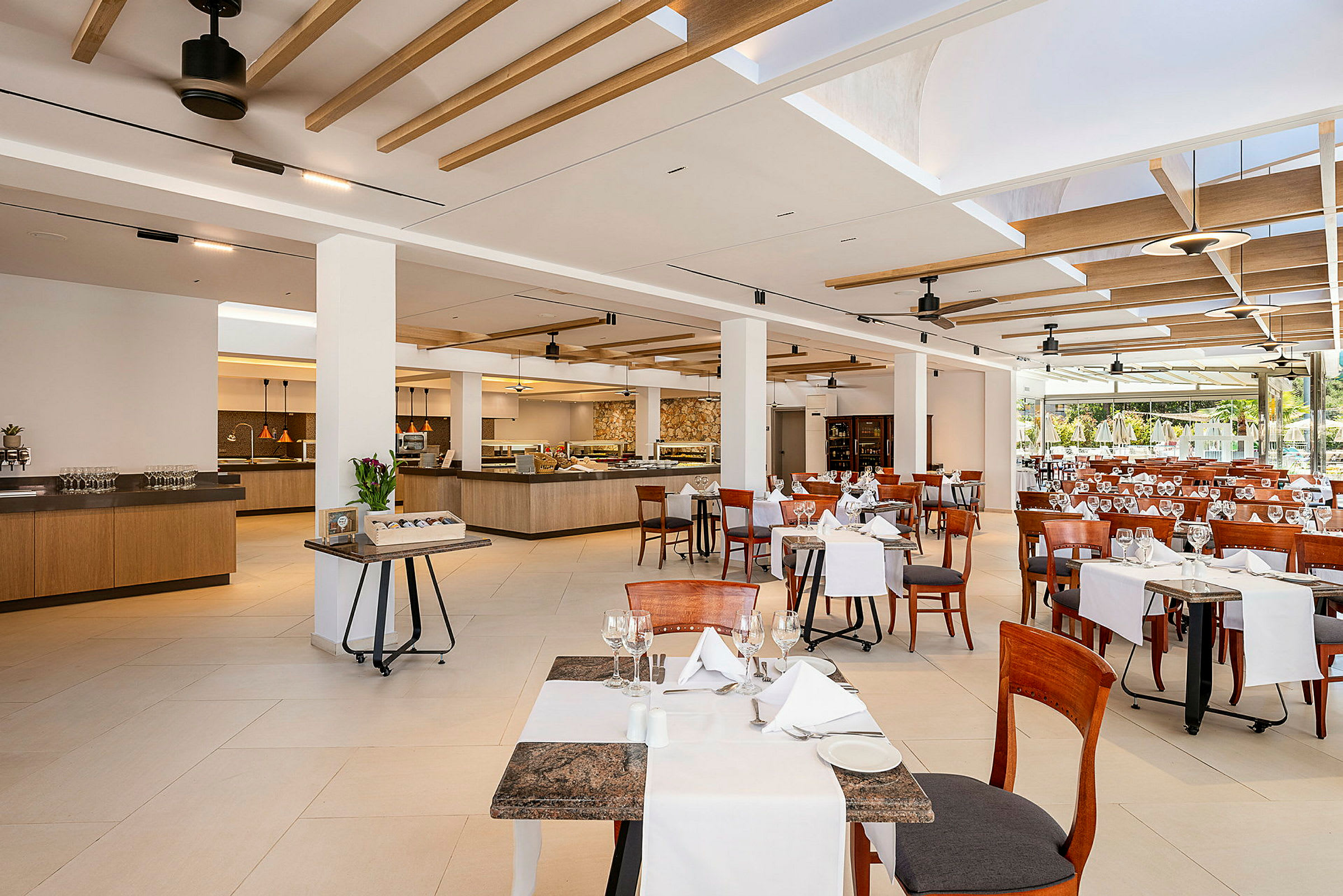Bild av en rymlig restaurang med dukade bord och stolar samt serveringsområden i bakgrunden. (AI-genererad text)