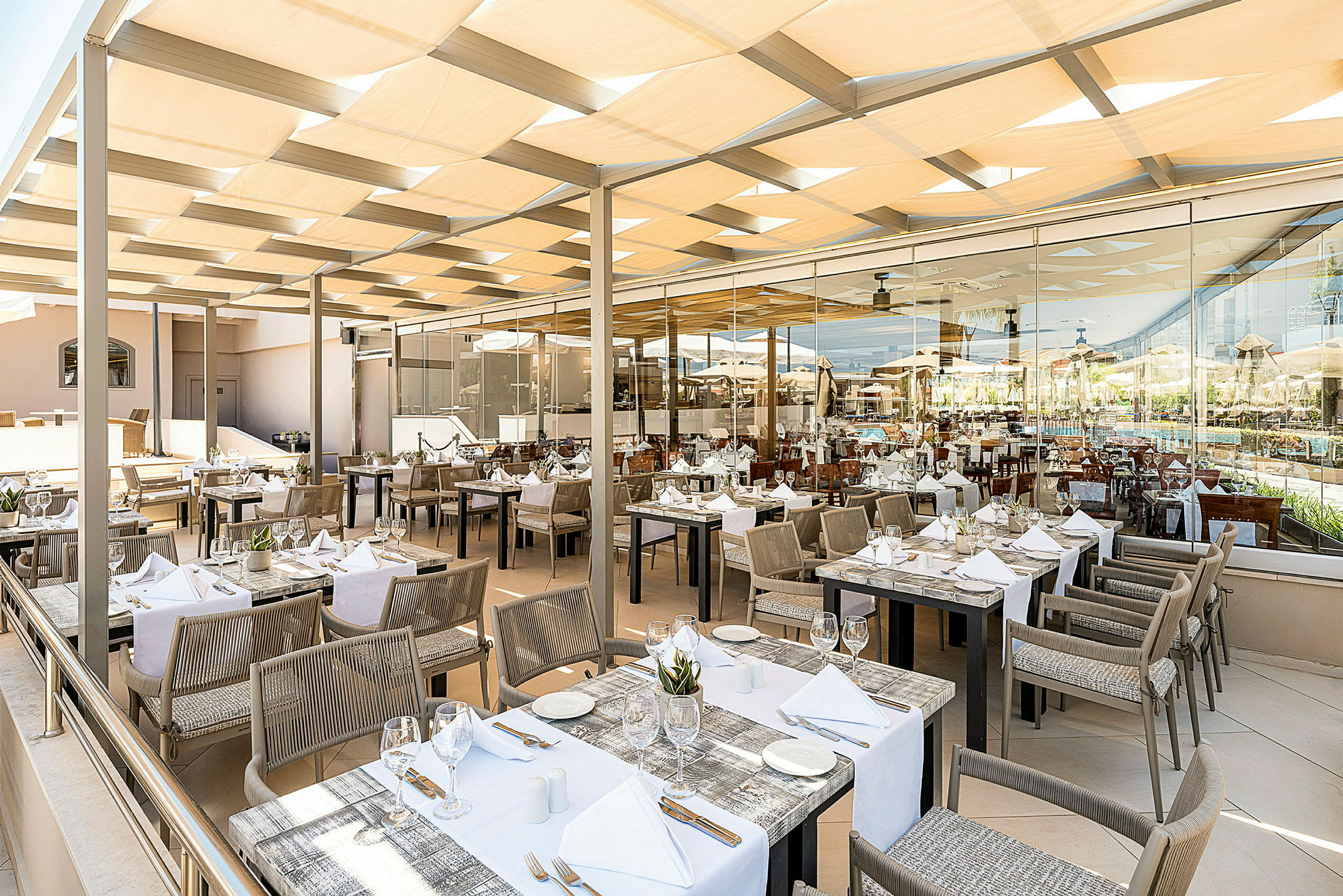 Restaurang med dukade bord utomhus under tak. (AI-genererad text)