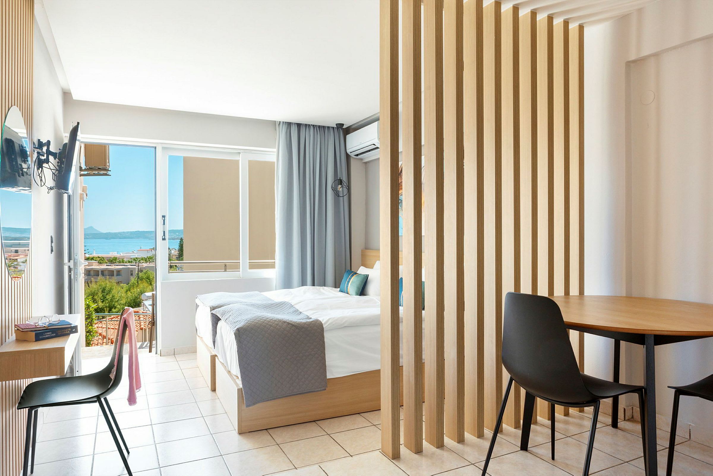 Ett ljust hotellrum med dubbelsäng och utsikt mot havet. (AI-genererad text)
