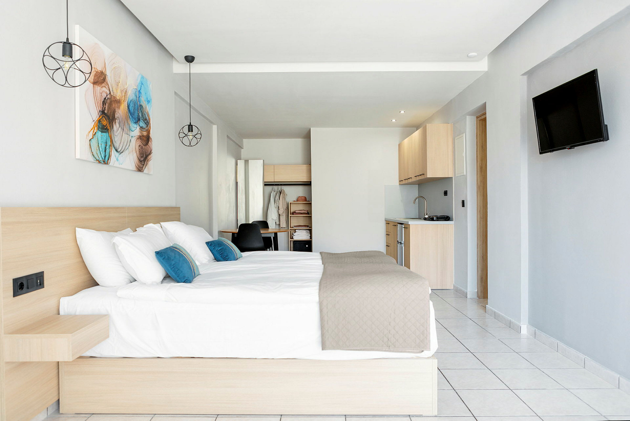 Ett hotellrum med en dubbelsäng, köksdel och rymlig inredning. (AI-genererad text)