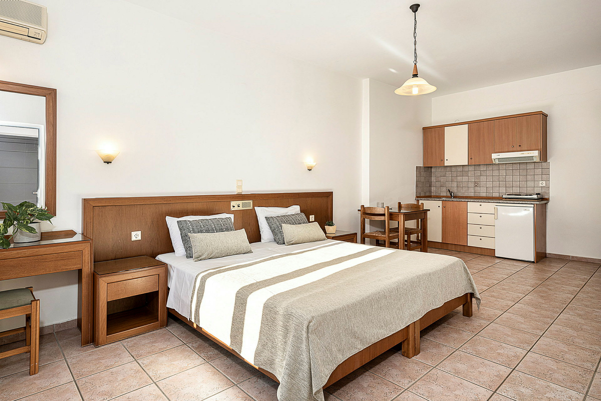 Rymligt hotellrum med dubbelsäng, skrivbord och fullt utrustat pentry. (AI-genererad text)