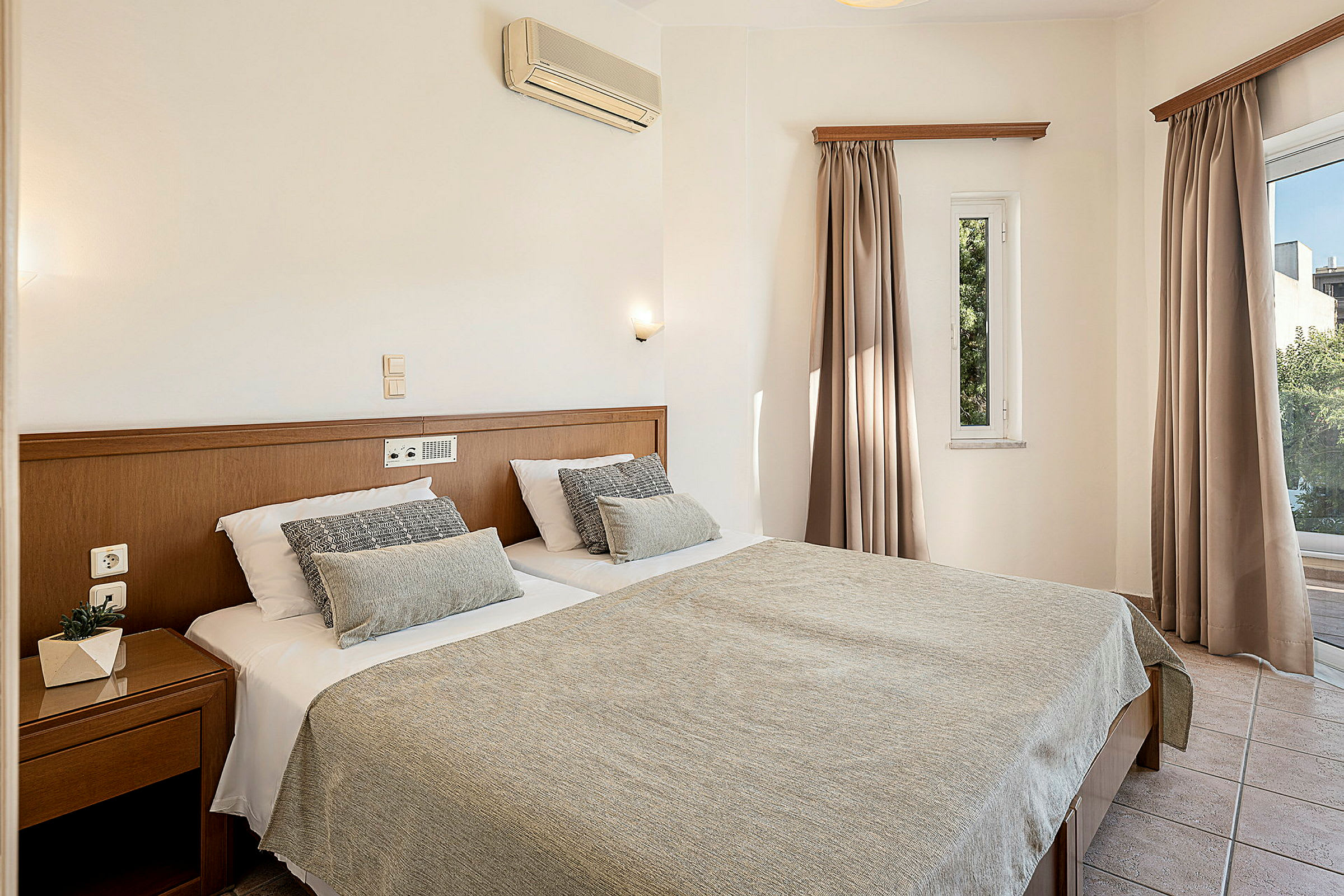 Ett hotellrum med en dubbelsäng och fönster. (AI-genererad text)