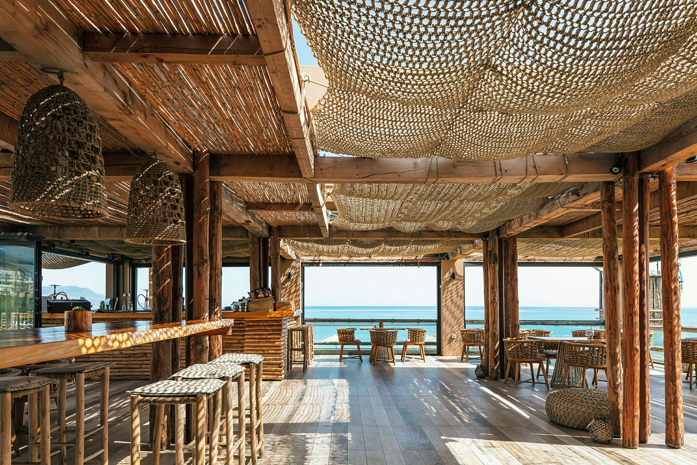 En strandnära restaurang med träinredning och utsikt mot havet. (AI-genererad text)