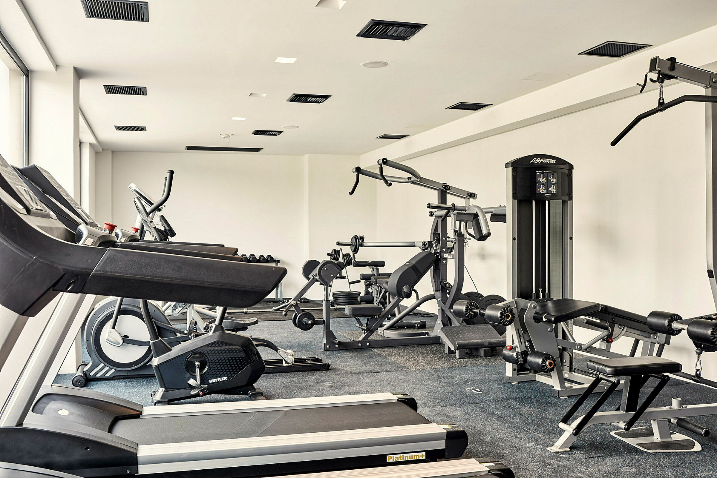 Ett gym med träningsmaskiner, löpband och vikter. (AI-genererad text)