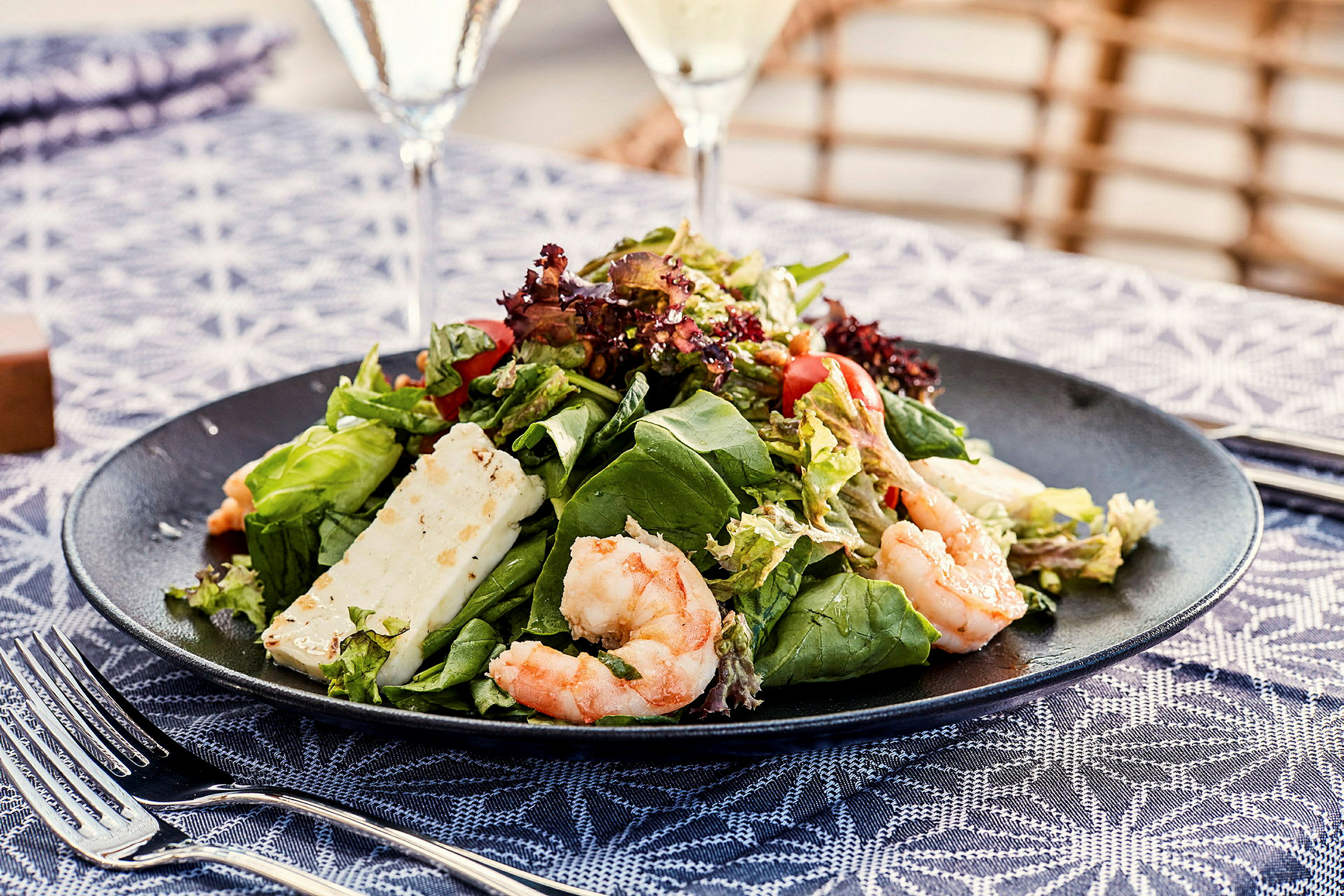 En tallrik med sallad, räkor och ost. (AI-genererad text)