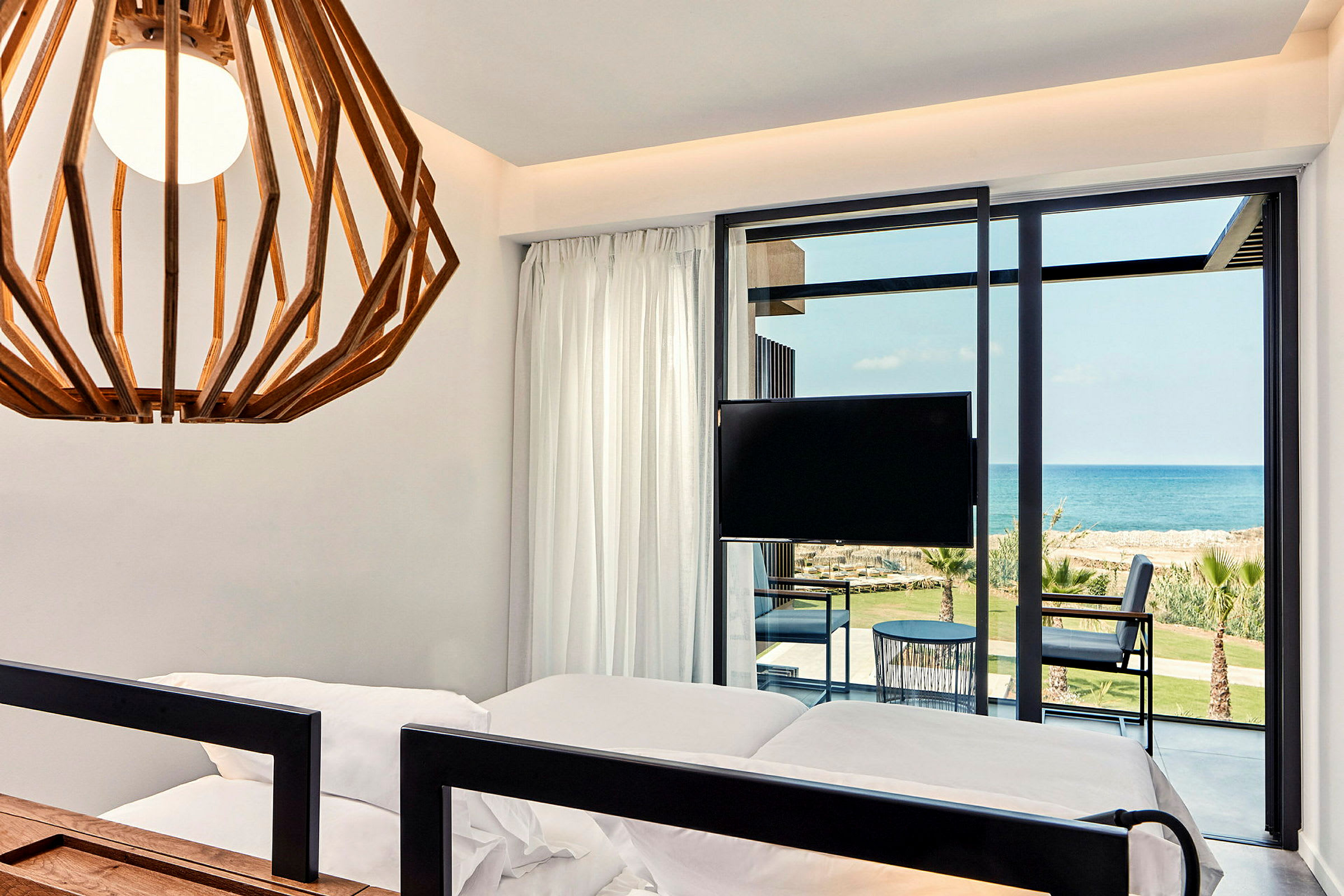 Hotellrum med modern inredning, havsutsikt och balkong. (AI-genererad text)