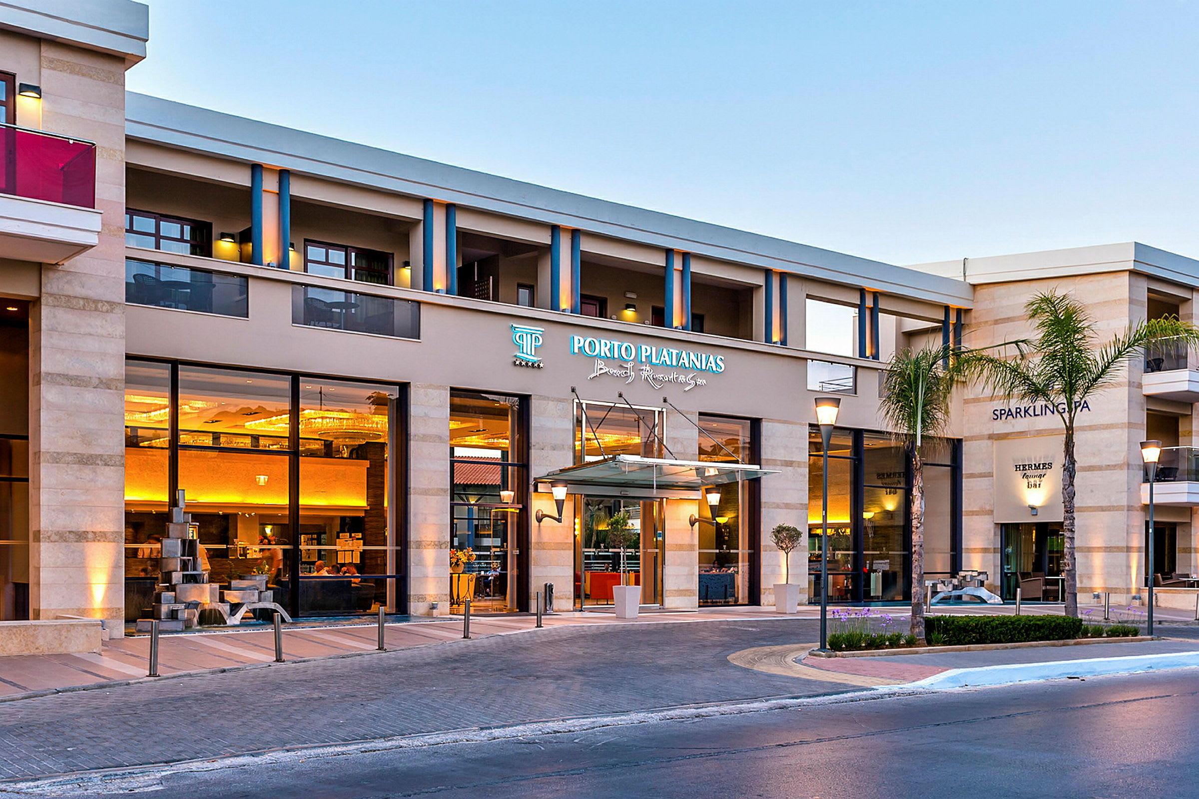 Hotellbyggnad med entré skyltad som Porto Platanias Beach Resort & Spa. (AI-genererad text)