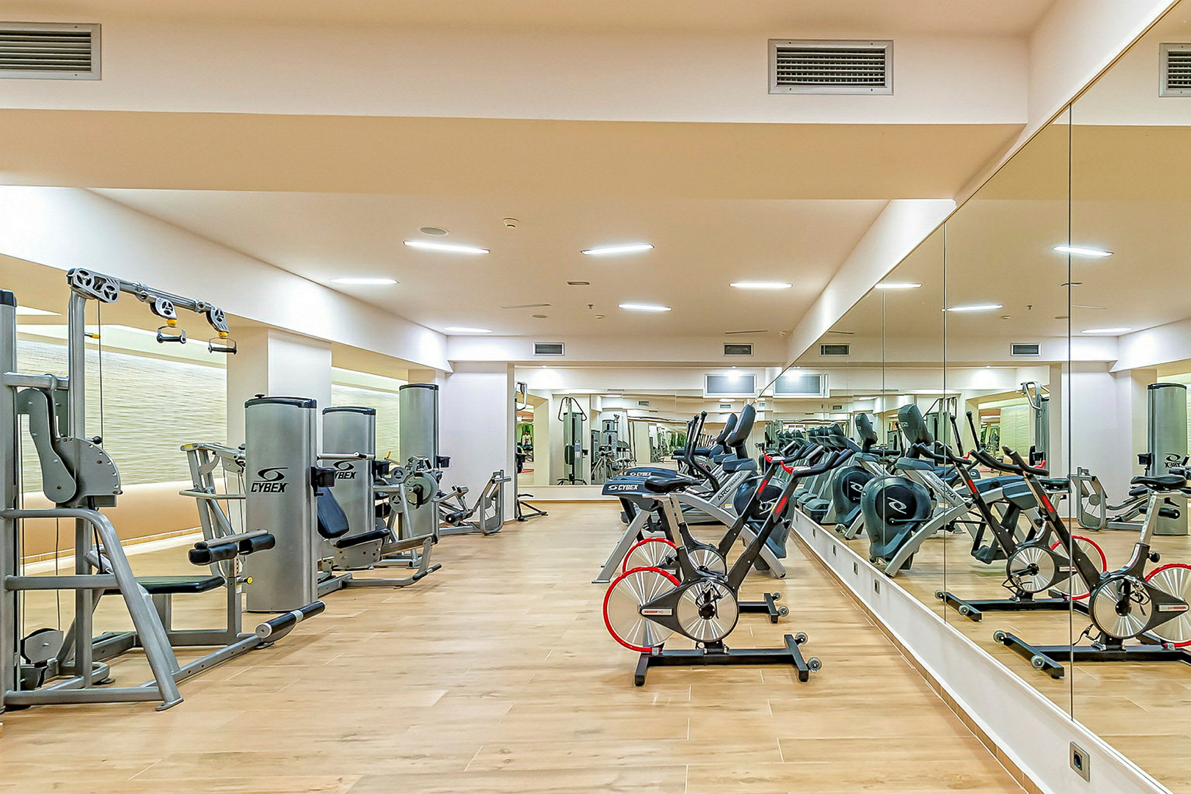 Gym med träningsmaskiner och speglar längs väggarna. (AI-genererad text)