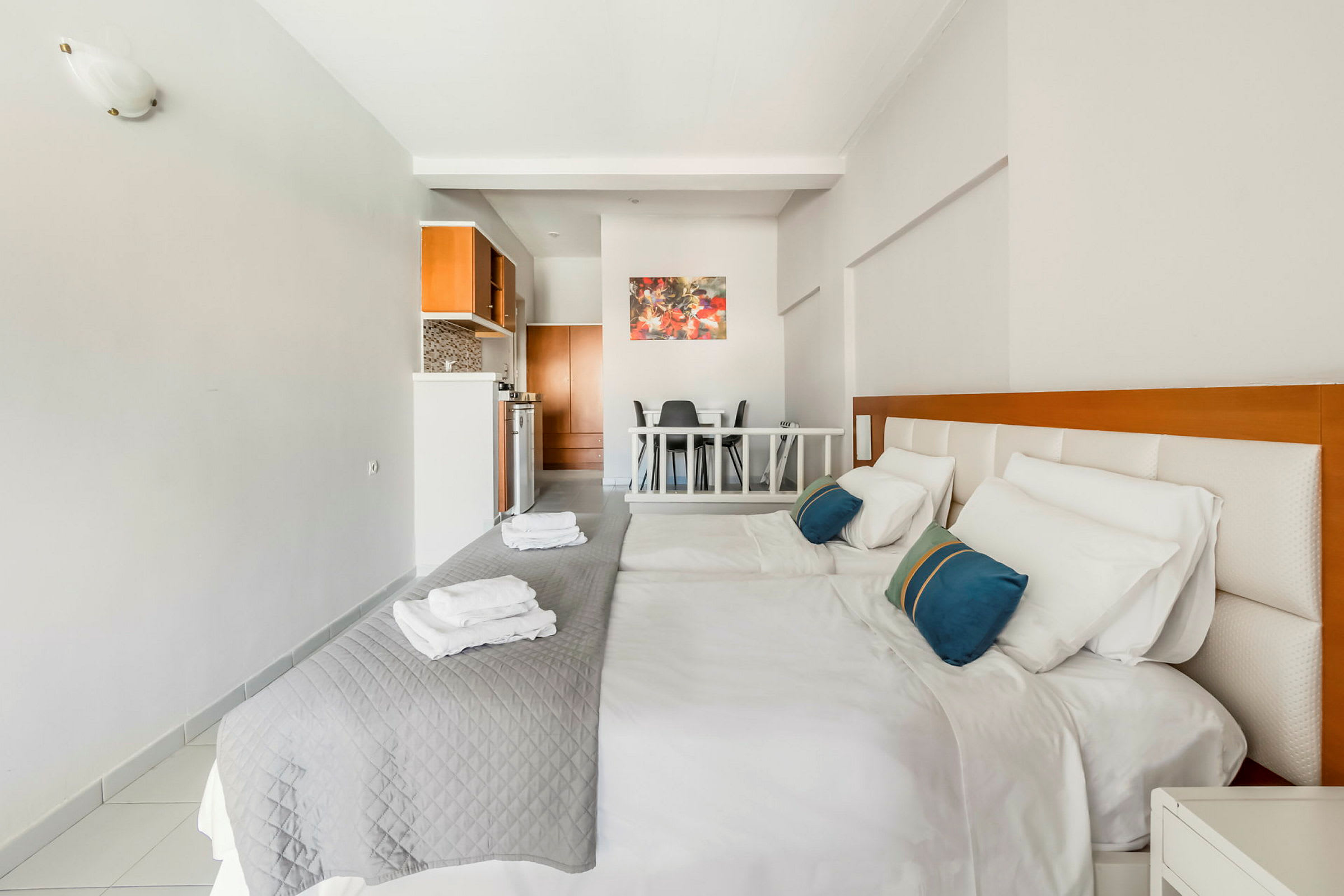 Ett hotellrum med två sängar och ett kök i bakgrunden. (AI-genererad text)