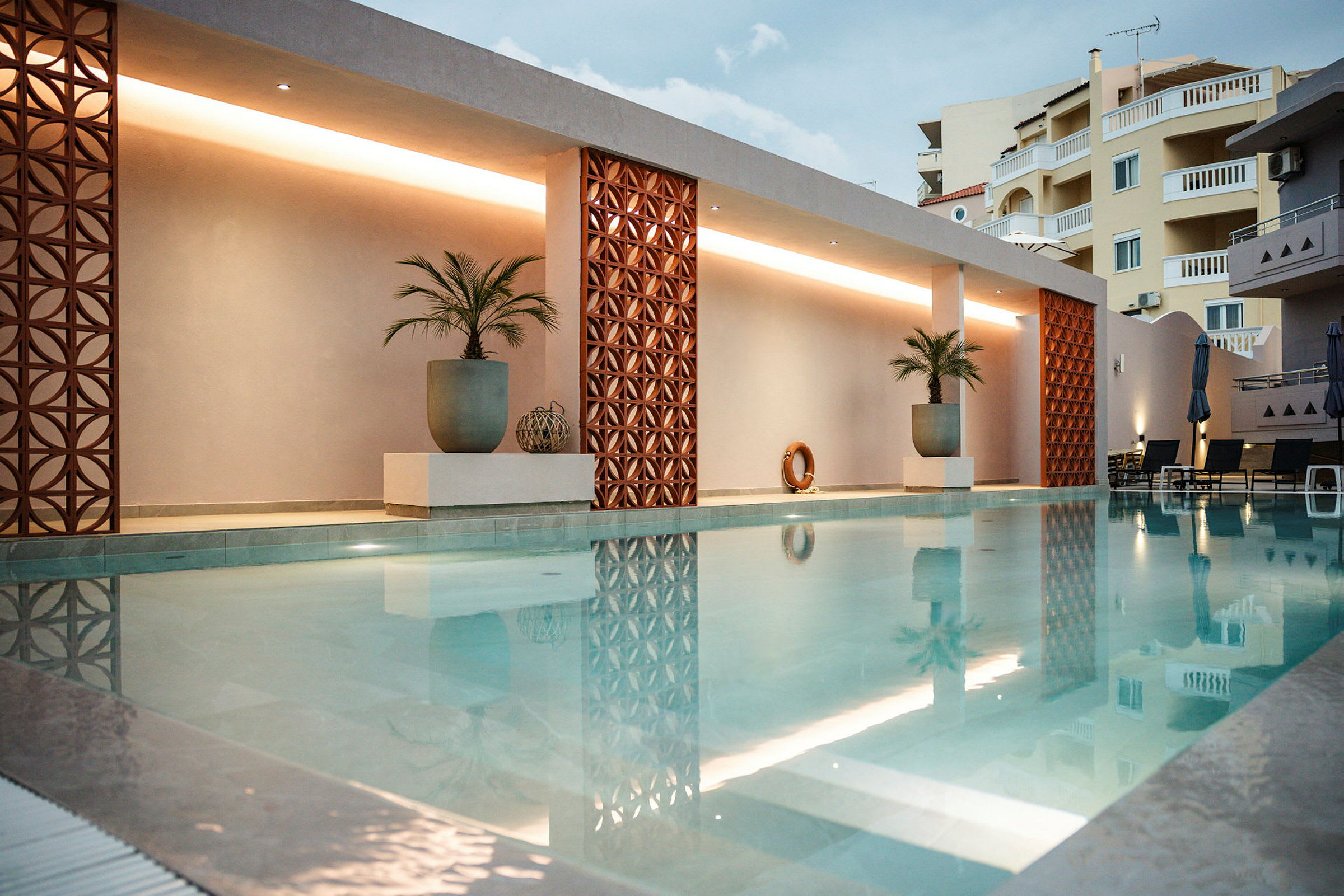 Modern swimmingpool med dekorationer och palmer. (AI-genererad text)