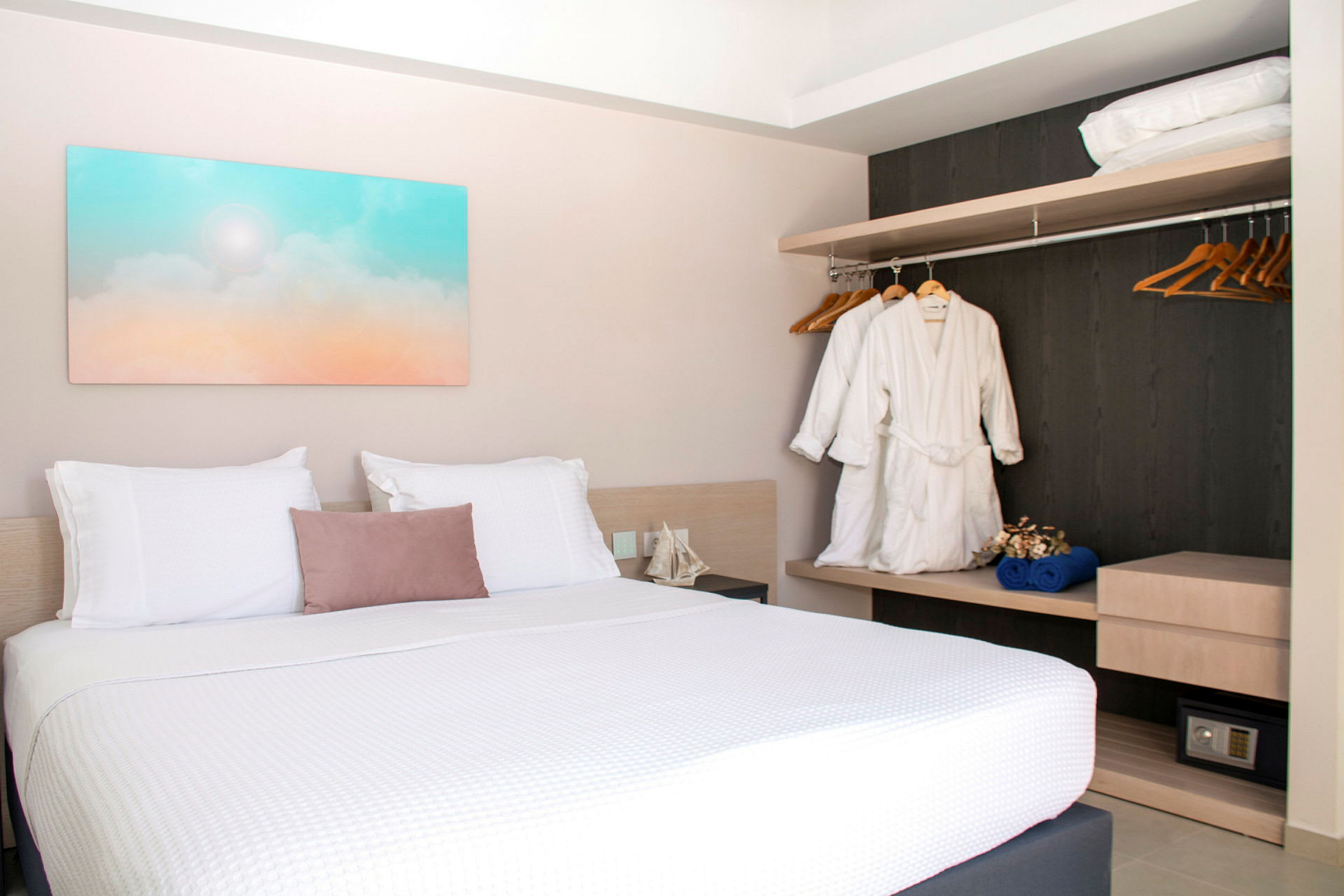 Hotellrum med dubbelsäng, väggkonst och garderob. (AI-genererad text)