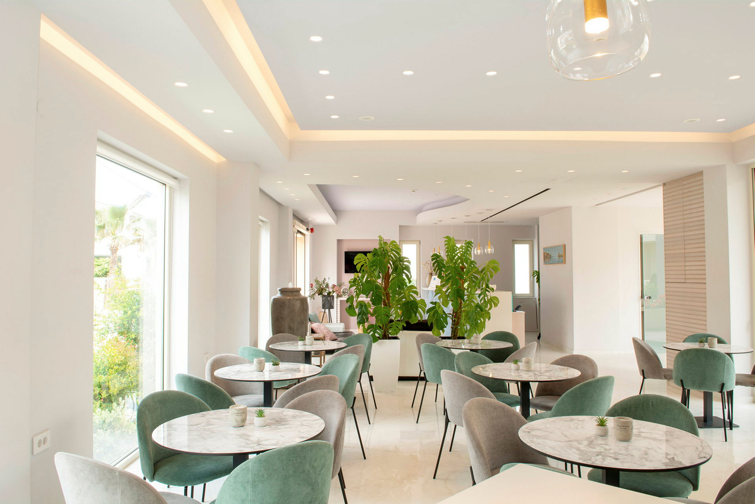 Modernt inredd restaurang med grönska och flera bord. (AI-genererad text)