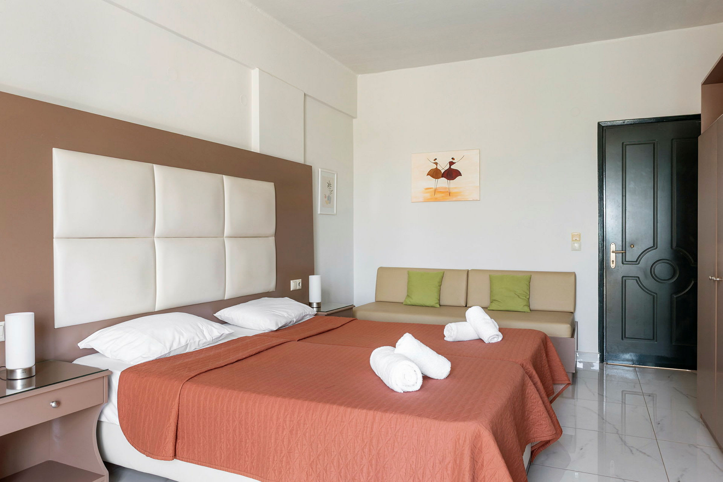 Hotellrum med två enkelsängar, örngott, en soffa och en dörr. (AI-genererad text)