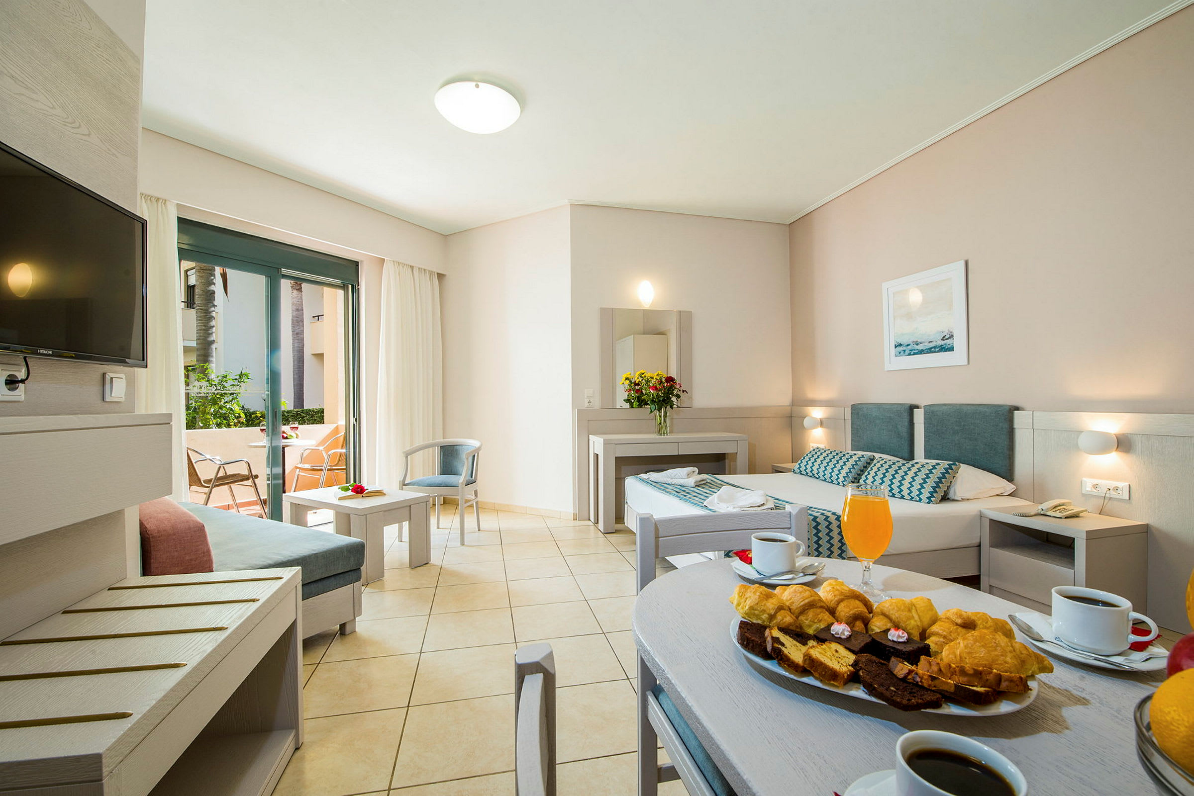 Modernt hotellrum med bekväm möblering. Utomhusområde synligt genom glasdörrar. (AI-genererad text)