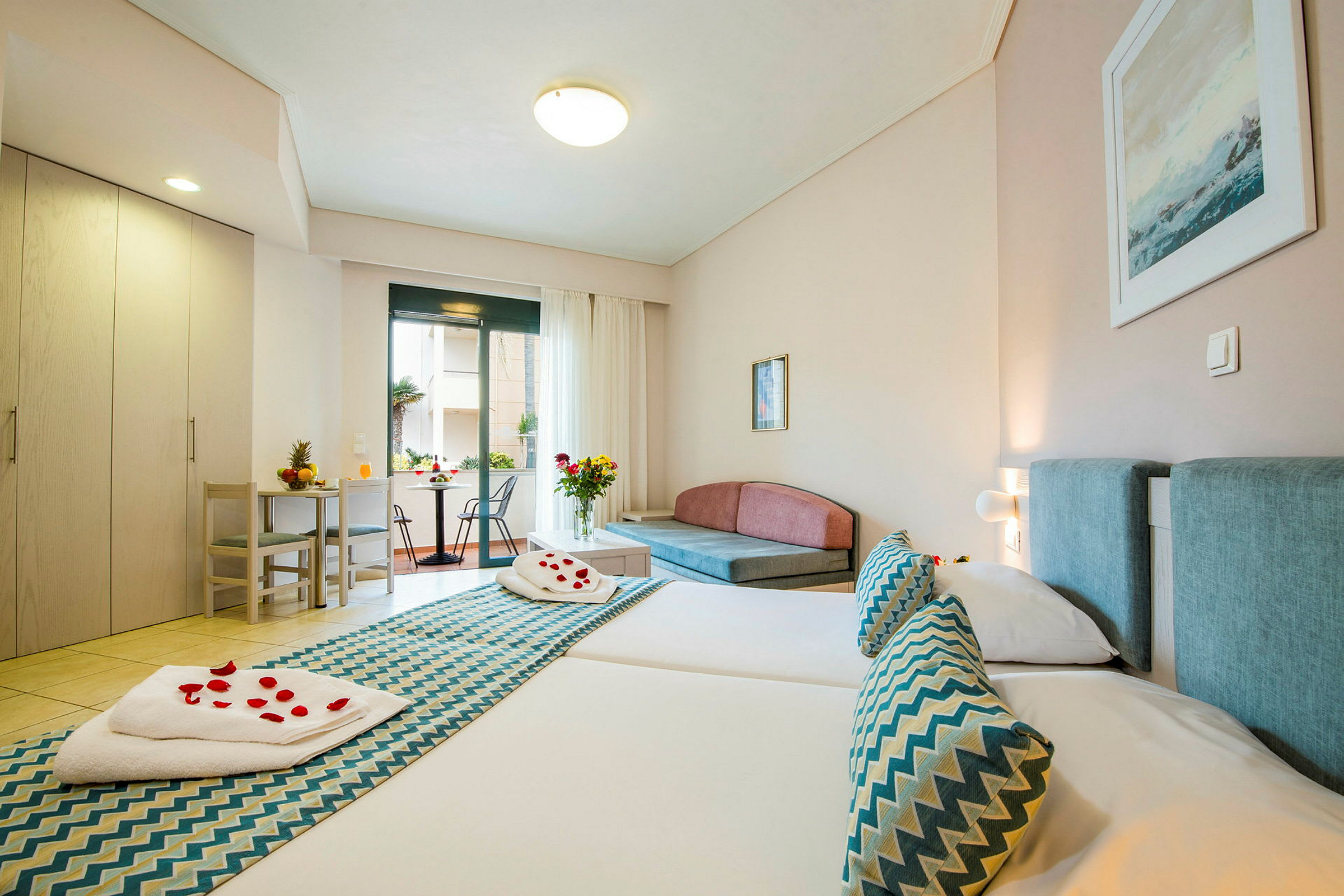 Hotellrum med två sängar, sittgrupp och utgång till balkong. (AI-genererad text)