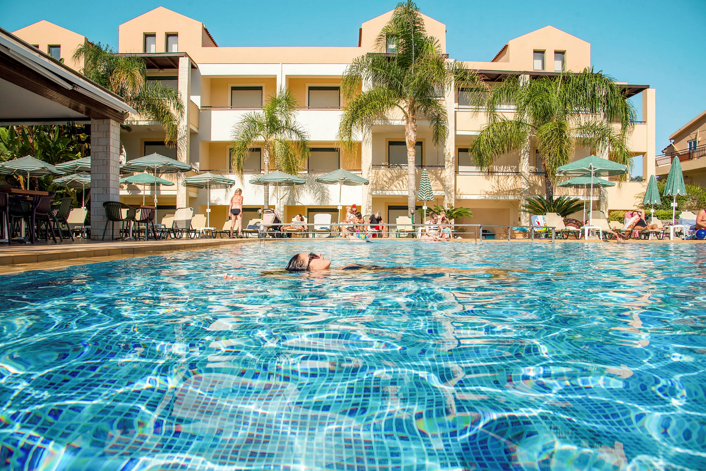 Bild på en pool med hotellbyggnaden i bakgrunden. (AI-genererad text)