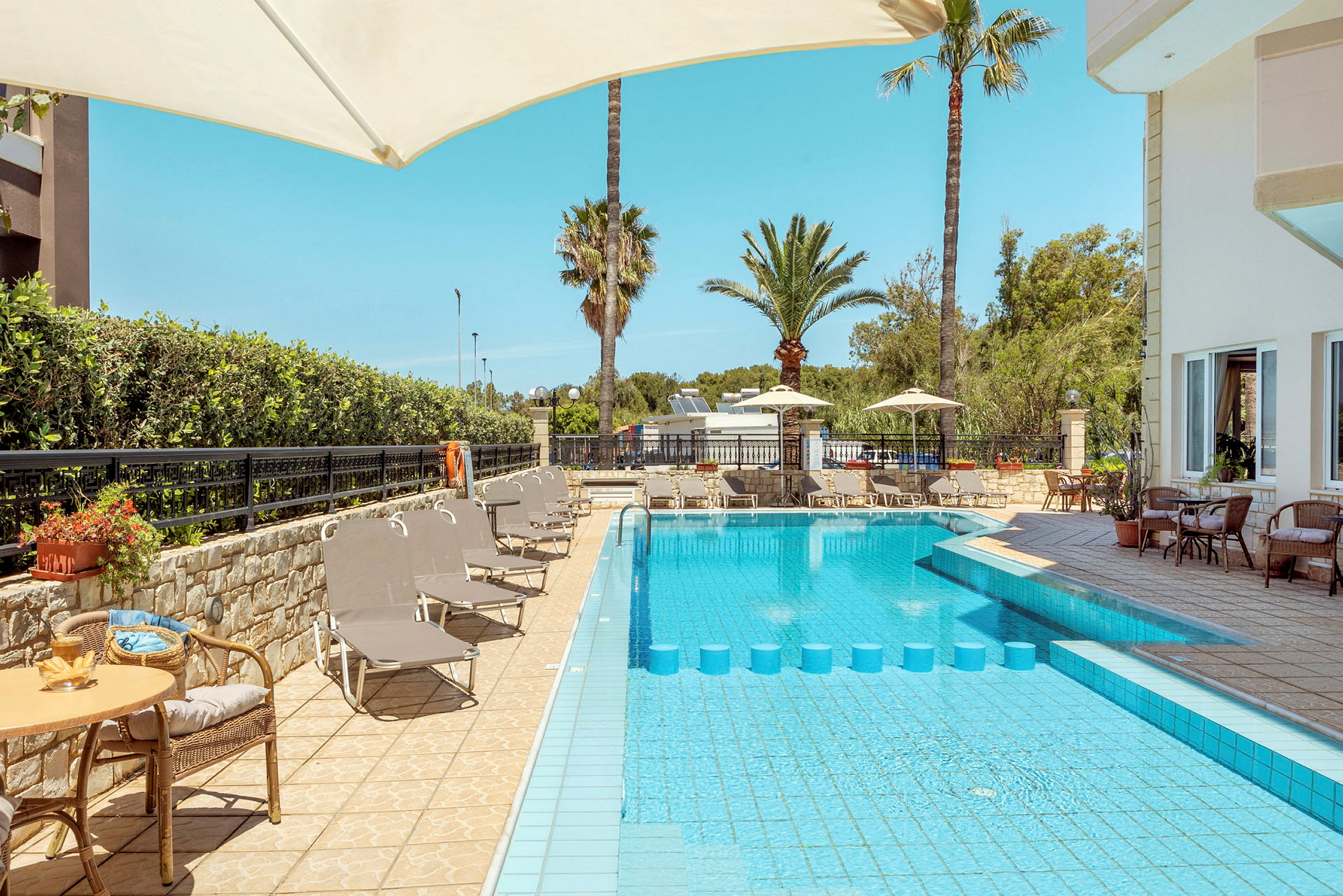 Utomhusområde med pool, solsängar och parasoller. (AI-genererad text)