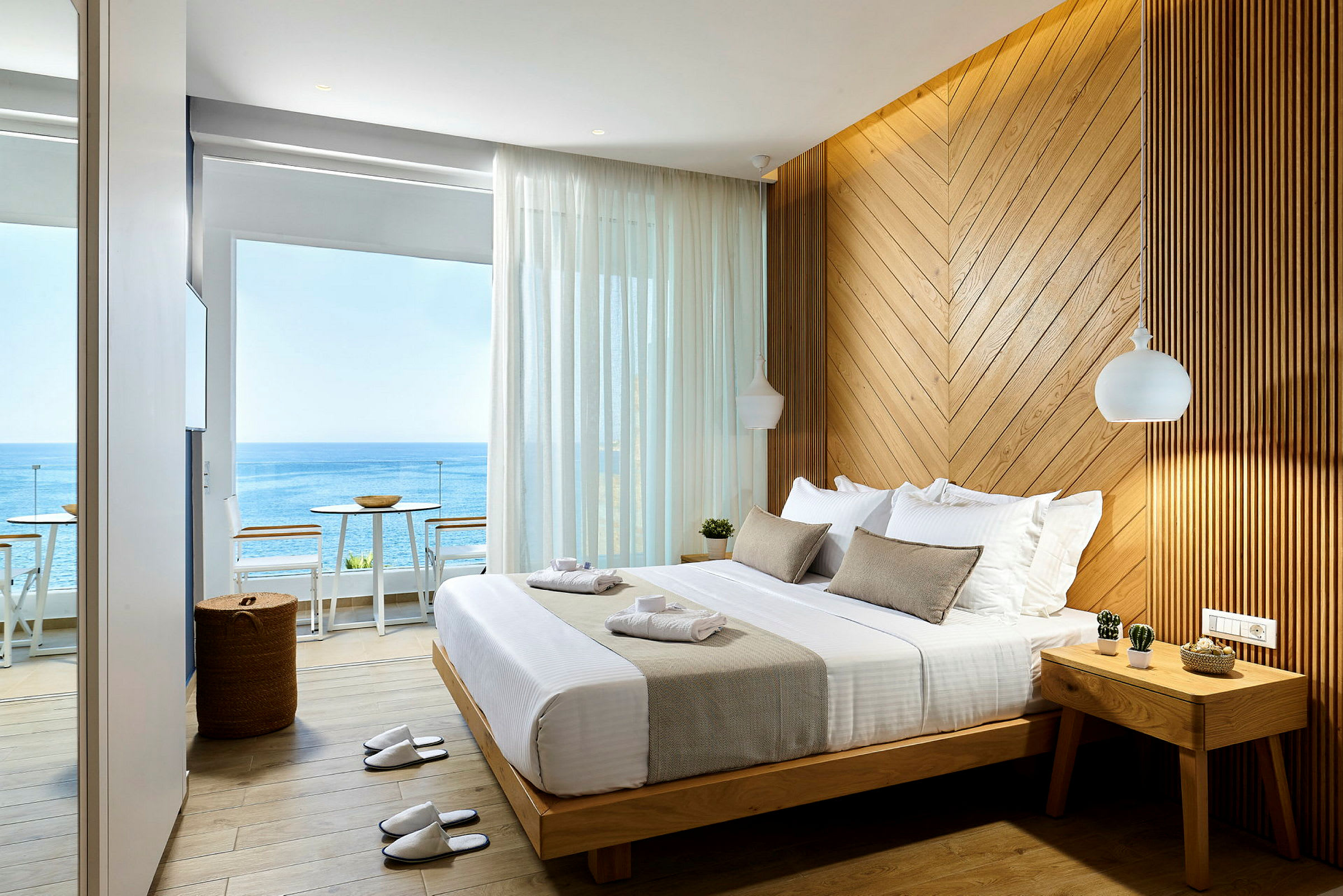 Ett hotellrum med havsutsikt, en stor säng och en vägg av träpanel. (AI-genererad text)