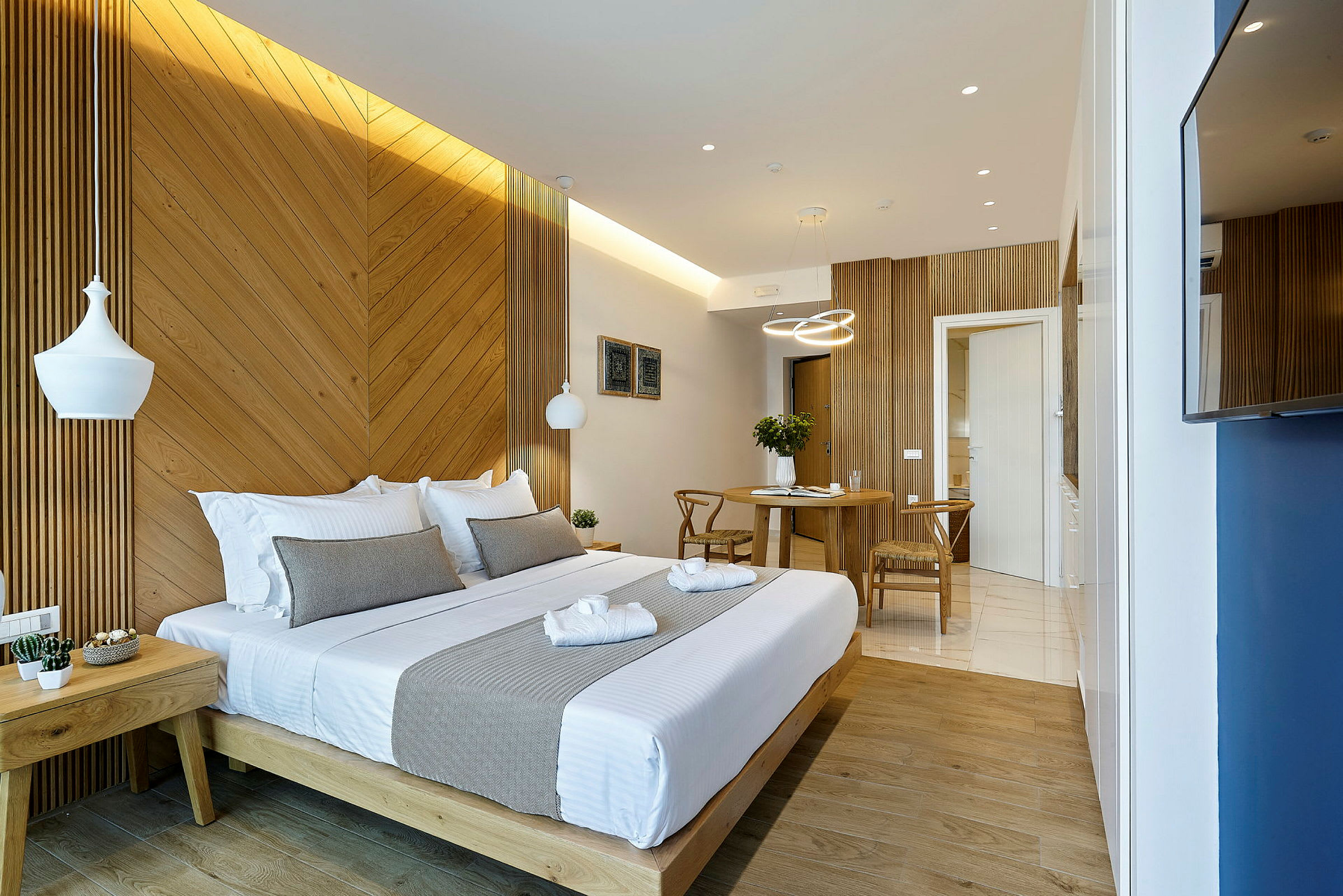 Ett väl upplyst hotellrum med en dubbelsäng och ett litet matbord. (AI-genererad text)